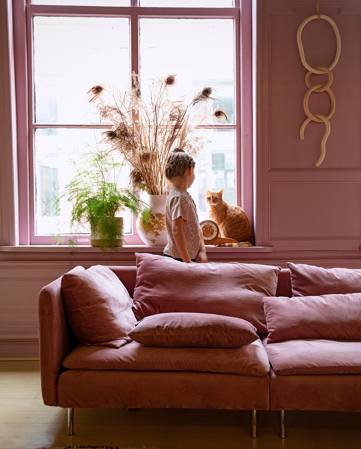 Verfkleur Velvet Plum van Painting The Past. Bank Söderhamn van Ikea met velvet hoes van Bemz. Plant Bloembinderij Rosafleur in pot Nørd conceptstore. Vaas Hella Jongerius voor Ikea, pluimen herkomst onbekend. Schouwklok van Susannes ouders. Keramische wandhanger Lydia Elisabeth Pottery.