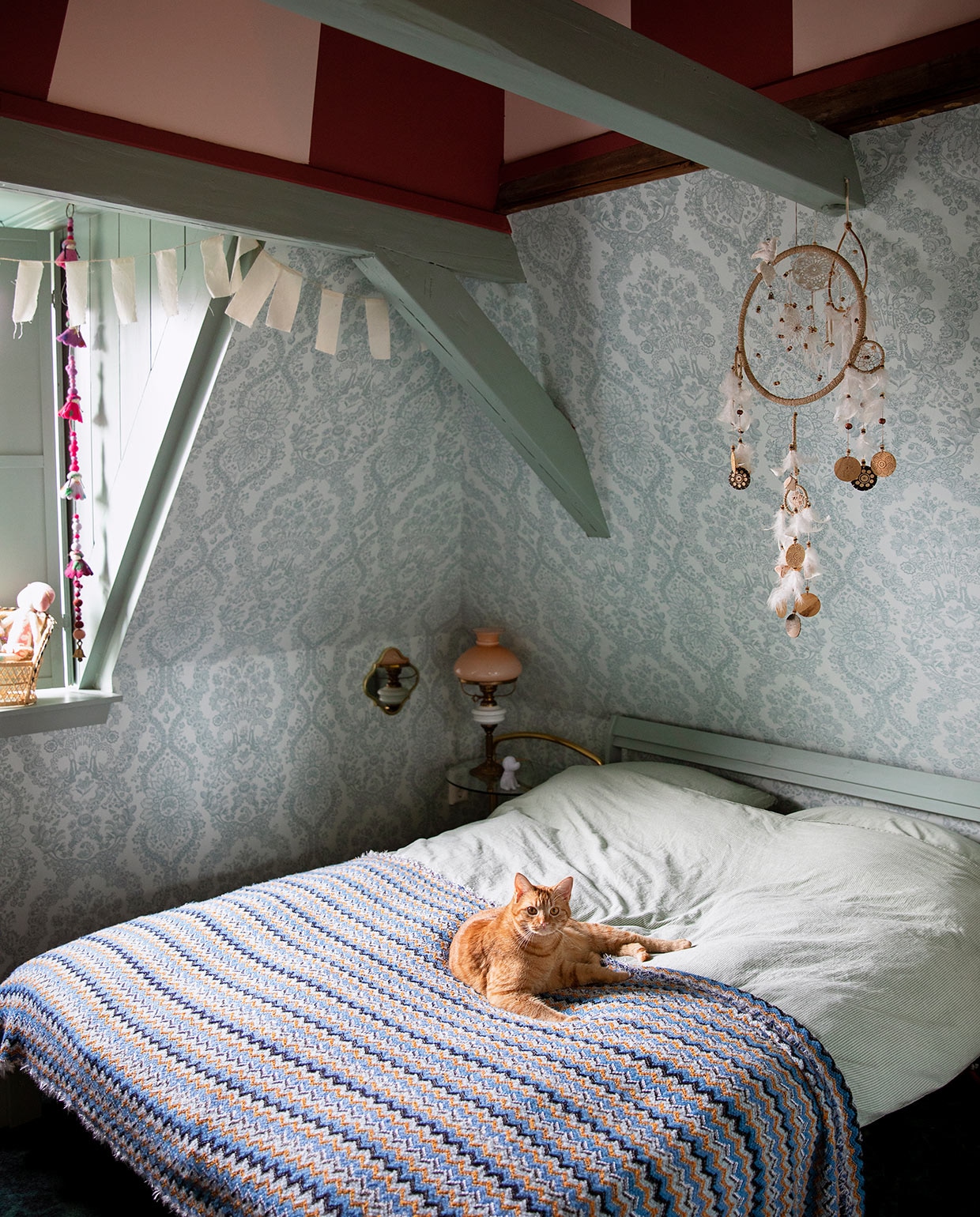 Verfkleur strepenprint Blossom en Dining Room Red, houtwerk Aloë Vera van Painting The Past. Behang Lacy Dutch van Pip Studio. Slinger Sukha. Wandspiegel H&amp;M. Nachtkastje Ouderwets Gezellig. Lamp kringloopwinkel. Bed Neiden en beddengoed Ikea. Dromenvanger wereldwinkel. Kwastjeskoord en sprei herkomst onbekend.