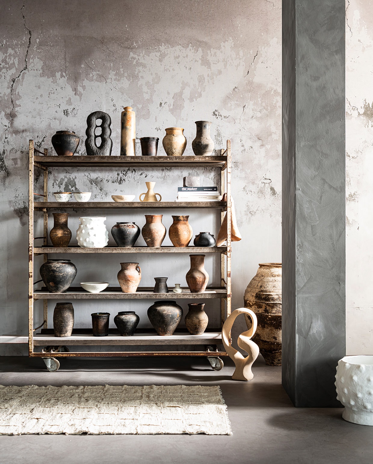 Behang uit Super Grunge collectie, per m² € 80,- (behangfabriek.com). Oud broodrek € 550,- (burbri.nl). Vloerkleed Bat’z Rug € 375,- (studio-yen.com). Grote oude oliekruik € 475,-, witte pot met bubbels Boule Blanc € 189,-, camel-kleurige linnen doek van Linge Particulier € 12, (couleurlocale.eu). Object Stoneware van Bloomingville € 85,- (vtwonen.nl). Bovenste plank: pot van gebakken klei € 35,-, lichte vaas van klei € 35,-, zwarte vaas van klei € 35, (burbri.nl). Object Guaja Sculpture van Malwina Kleparska € 450,- (studio-yen.com). Lange vaas € 126,-, lage zwarte pot € 42,- (couleurlocale.eu). Tweede plank: 2 witte schalen van Madam Stoltz, per stuk € 9,75 (deens.nl). Lage witte schaal € 63,-, kandelaar zandloper grote oren € 35,- (couleur- locale.eu). Vaas uit Earth collectie€ 50,-, boek Bea Mombaers € 43,50 (studio-yen.com). Overige boeken privébezit. Middelste plank: vaas van klei € 35,-, vaas zwart € 35,-, vaas terracotta € 35,-, vaas terracotta € 35,- (burbri.nl). Witte vaas met bubbels Boule Blanc € 165,- (couleurlocale.eu). Lage zwarte vaas van Madam Stoltz € 16,- (deens.nl). Een na onderste plank: grote zwarte vaas € 65,-, vaas met oor terracotta € 35,-, hoge vaas terracotta € 35,- (burbri.nl). Witte schaal uit set van 3 van Madam Stoltz € 47,50, kleine witte kruik uit set van 4 van Madam Stoltz € 20,75 (deens.nl). Kleine zwarte vaas uit Earth collectie € 30,- (studio-yen.com). Onderste plank: ovalen zwarte pot € 42,-, cilindervormige zwarte pot € 42,- (couleurlocale.eu). Lage vaas € 35,-, hoge vaas € 65,-, zandlopervormige vaas € 35,- (burbri.nl).