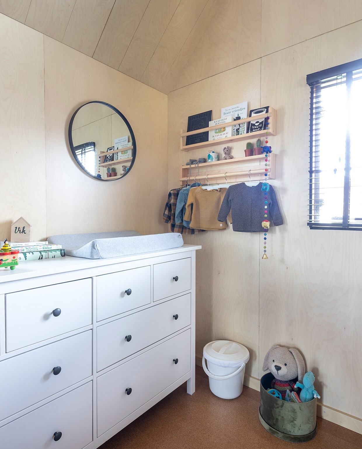 Kast  doet dienst als commode en wandrek Flisat als boekenplank én kledingroede, beide Ikea.