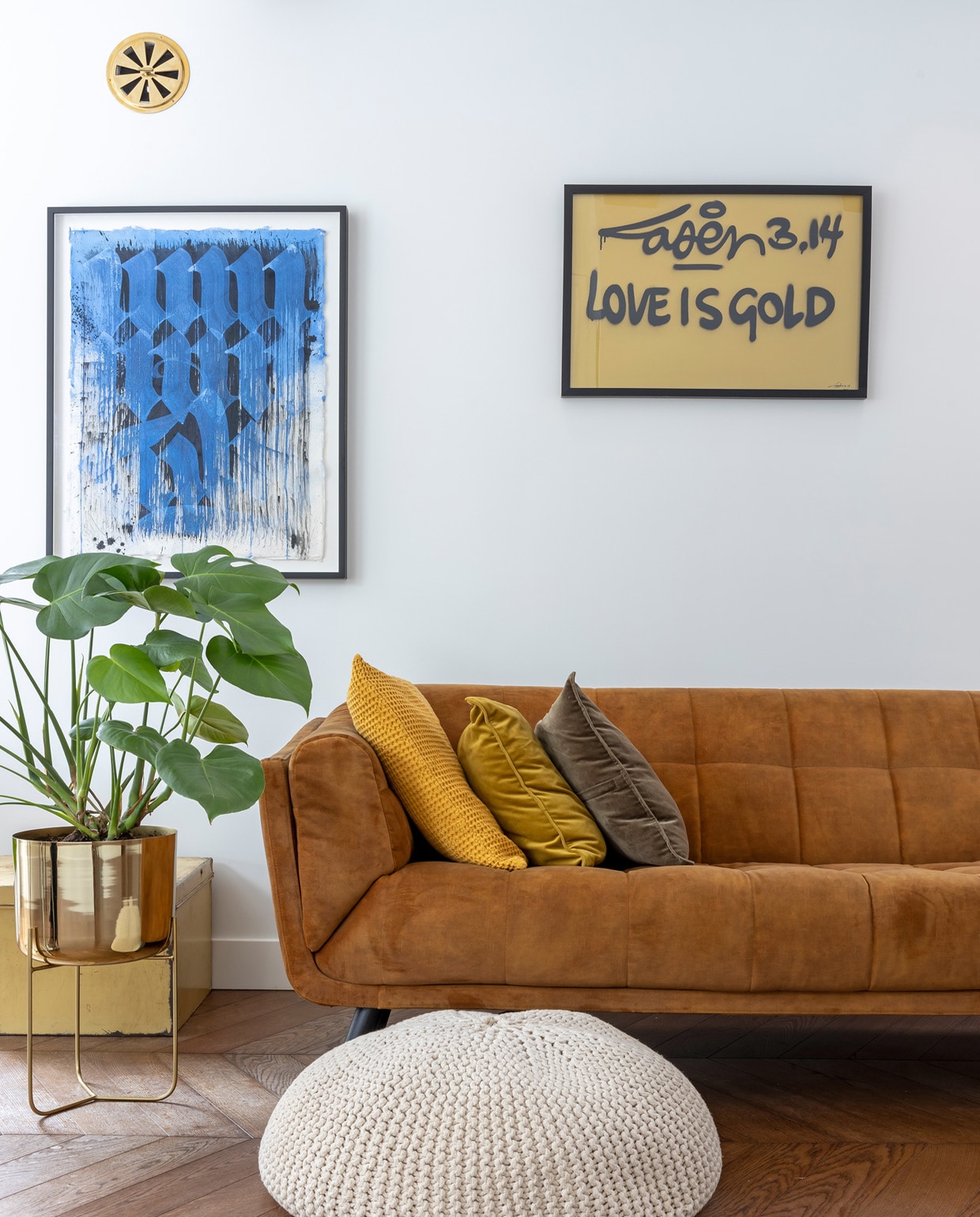 Eikenhouten vloer via de aannemer. Ventilatierooster Weijntjes hang- en sluitwerk. Kunstwerk Unruly van Niels ‘Shoe’ Meulman, gekregen van een goede vriend. Goudkleurig kunstwerk van de bevriende urban artist Laser 3.14. Bank Decor Amsterdam. Kussens Made. Vintage kist en poef cadeau gekregen. Plantenpot Zara Home.