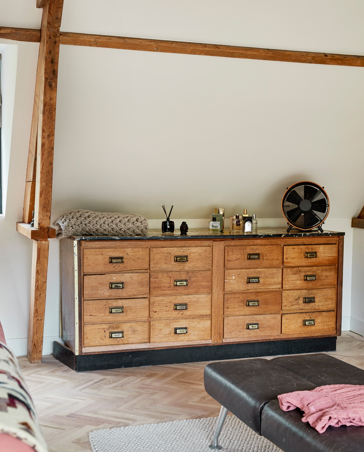 Ladekast vintage, ventilator Anno Design, parfum Retreat, sprei zelf gehaakt. Houten vloer Balkan Wood, vloerkleed Hay, bank herkomst onbekend, kleding Zara.