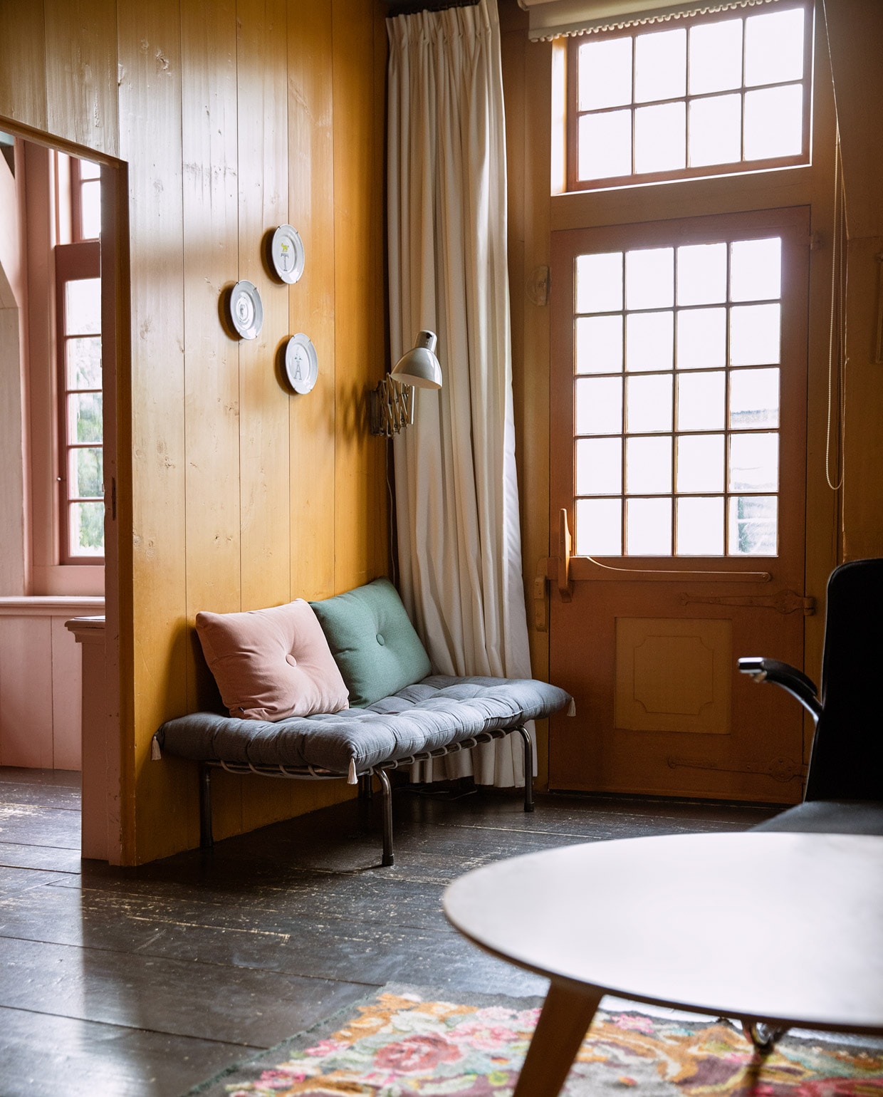 Borden aan muur Anouk Kramer, gordijnen Hema. Bank Numero 74, matraskussen Archive Store, kussens Hay. Stoel Gispen, salontafel Loods 5, Moldavisch vloerkleed Brechtje Olsthoorn Interiors.