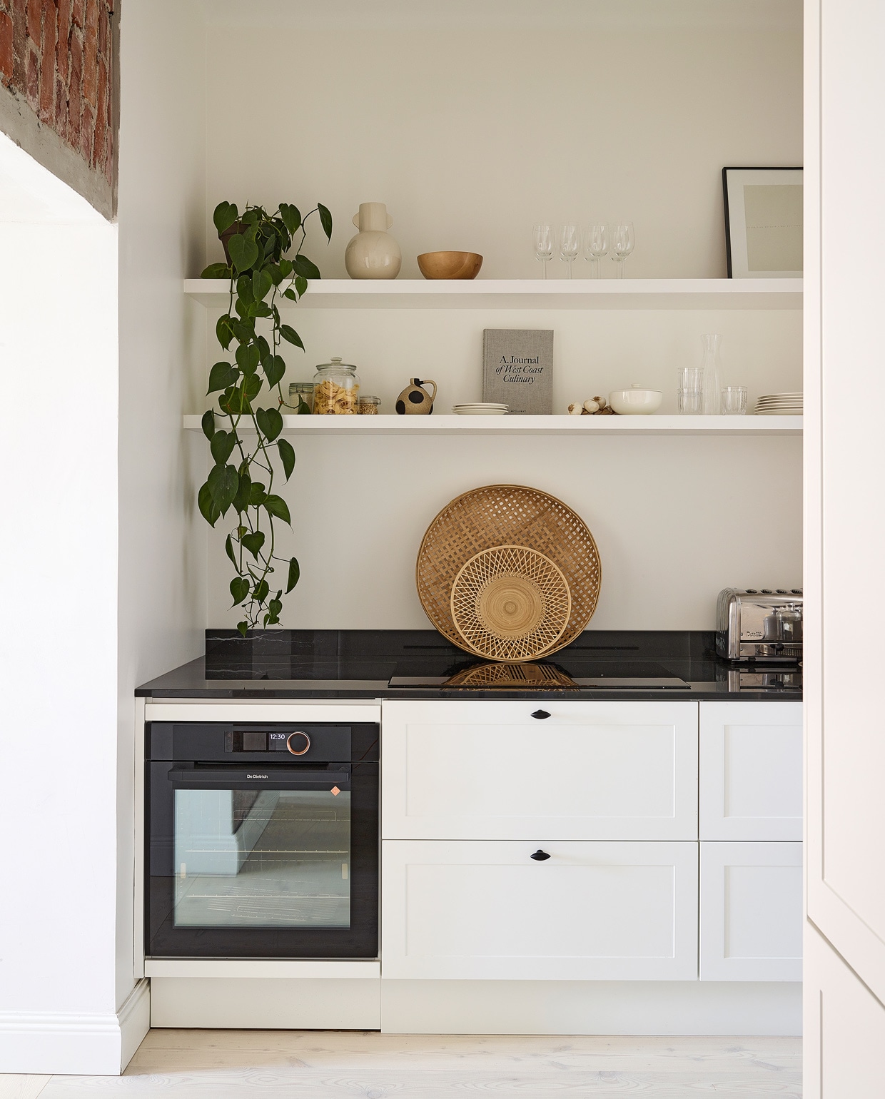 Keuken Nixi. Houten kapstok gemaakt in opdracht. Zwarte cocktailshaker Cosmopolitan Bolia, theebox Teministeriet tea, vaas, wit bord, glazen verstuiver en glazen fles vintage.