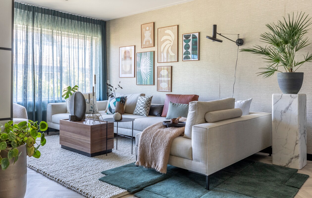 Flexa Creations muurverf en lak op kozijnen F7.04.77 (flexa.nl). Behang Siroc 376040, per rol € 53,95, gordijnen Enif 7896-11, per meter € 44,95 (eijffinger.com). Kunst gemaakt door Esther en Marijn, per stuk vanaf € 99,- (enkelartstudio.com). Lijsten per stuk vanaf € 77,- (delijstenfabriek.nl). Elementenbank van Design on Stock in stof Senna prijs op aanvraag, rugkussens van Design on Stock, per stuk vanaf € 199,-, groen vloerkleed van Design House Stockholm € 1931,-, lamp Solid € 110,-, vulkussens van Claudi, per stuk vanaf € 6,95, kussenhoezen van Claudi vanaf € 52,95, grijze vaas van 101 Copenhagen € 130,-, bol van Nicolas Vahé € 33,75 (eijerkamp.nl). Vloerkleed Pebbles Ivory € 1700,- (cunera.nl). Plaid € 99,- (bymolle.com). Bijzettafel van vtwonen € 293,- (basiclabel.nl). Ronde bijzettafel € 219,99, kandelaars per stuk vanaf € 49,99 (kwilleminhuis.nl). Kaarsen per stuk € 0,95 (dille-kamille.nl). Bruine vaas € 50,-(101cph.com). Dienblad € 24,99 (hm.com). Koppen van Serax, per stuk € 12,40 (vtwonen.nl). Lepels per stuk € 5,50 (hkliving.nl). Bloemen, planten (waterdrinker.nl).