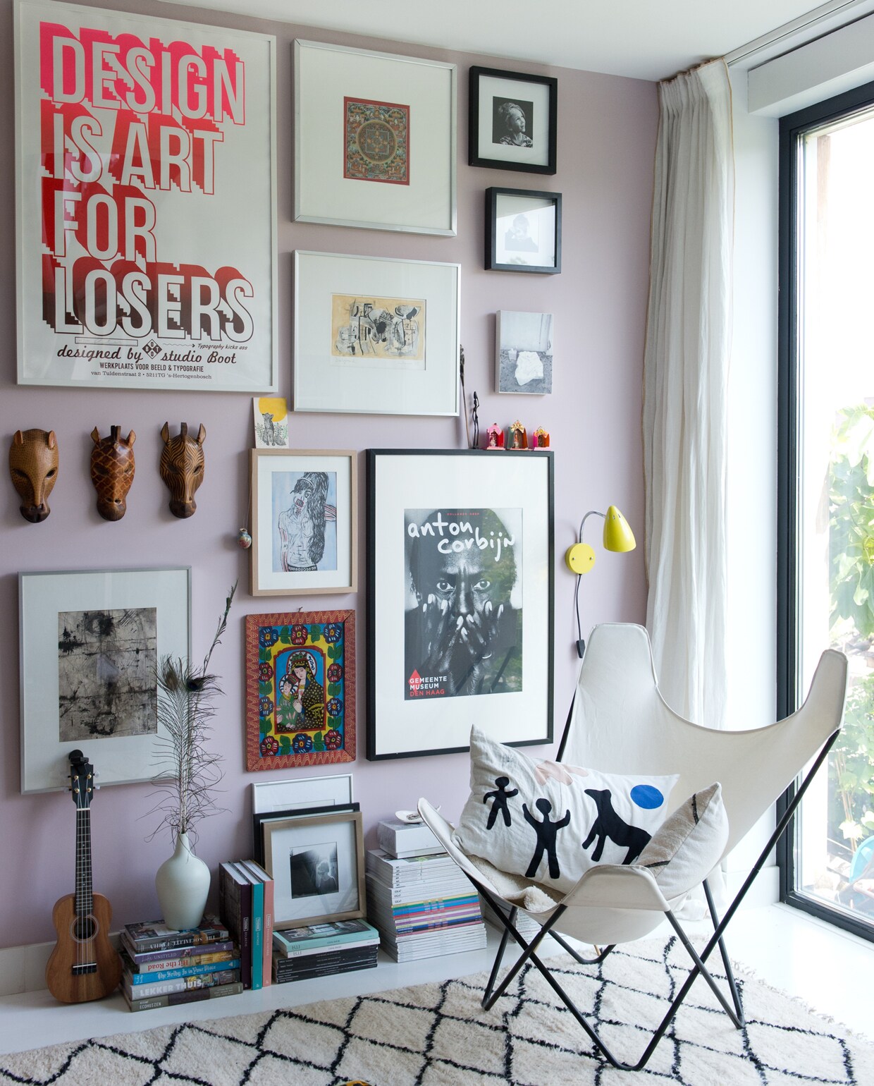 Kunst, posters en prints van o.a. Studio Boot, Ivonne van der Velden, Anton Corbijn, Frank Willems en Mark Rothko. Witte lamp Tolomeo van Artemide. Chesterfieldbank marktplaats.nl. Vintage Jieldé lamp. Geel muurlampje Waterquest. Kleed uit Marokko. Kussens van stof uit Tanzania. Vlinderstoel erfstuk. Kussen Neeltje Geurtsen. Houtkachel Bullerjan. Roze verf Noa van Fairf.