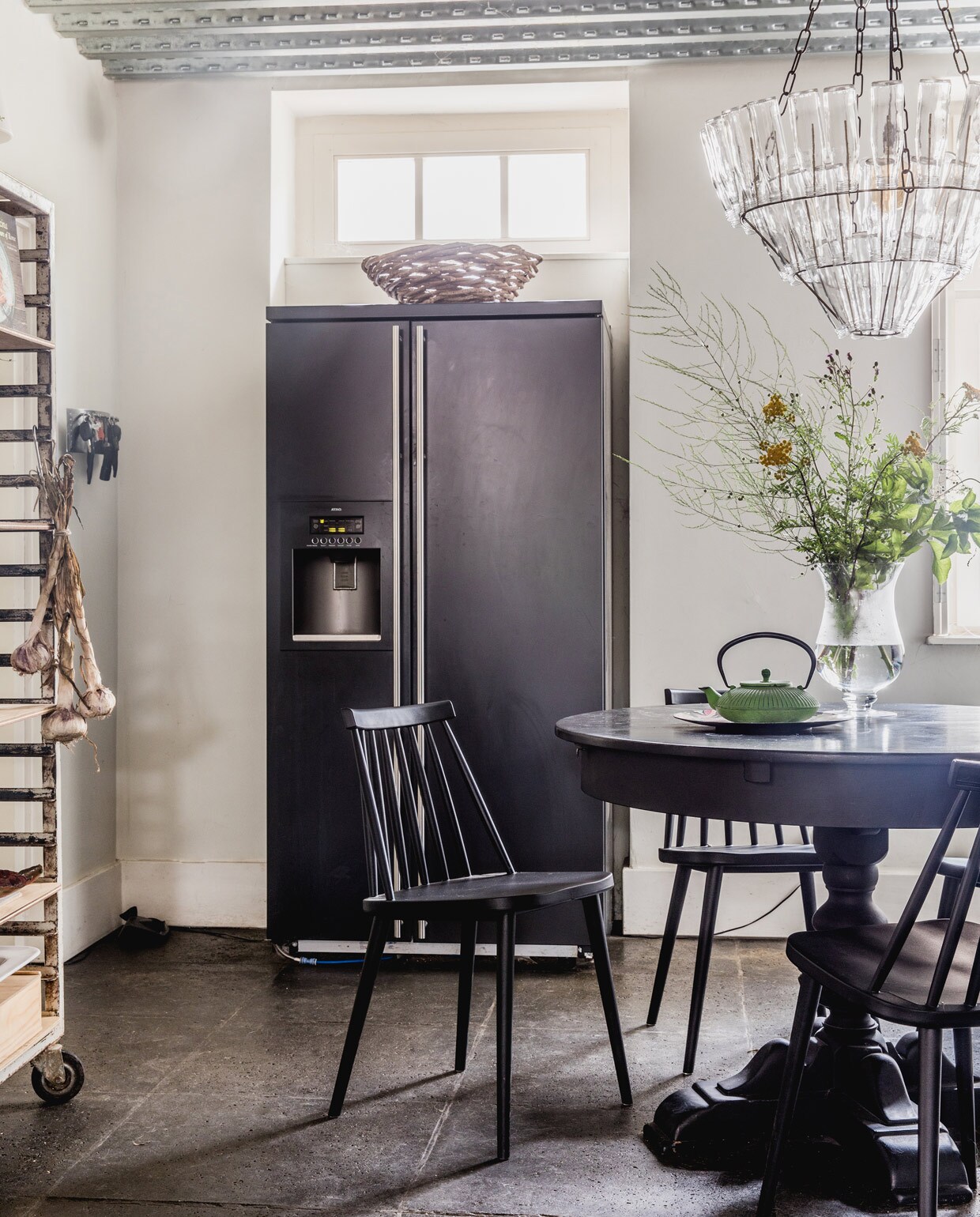Keukentafel gekregen, zelf zwart geschilderd. Designstoelen J77 van Hay via Flinders. Vintage Chinese theepot uit Frankrijk, vergelijkbare te koop bij Dille &amp; Kamille. Vintage vlaaienrek Hof Tongerlo. Lamp van lege flessen Leitmotiv. Koelkast herkomst onbekend.