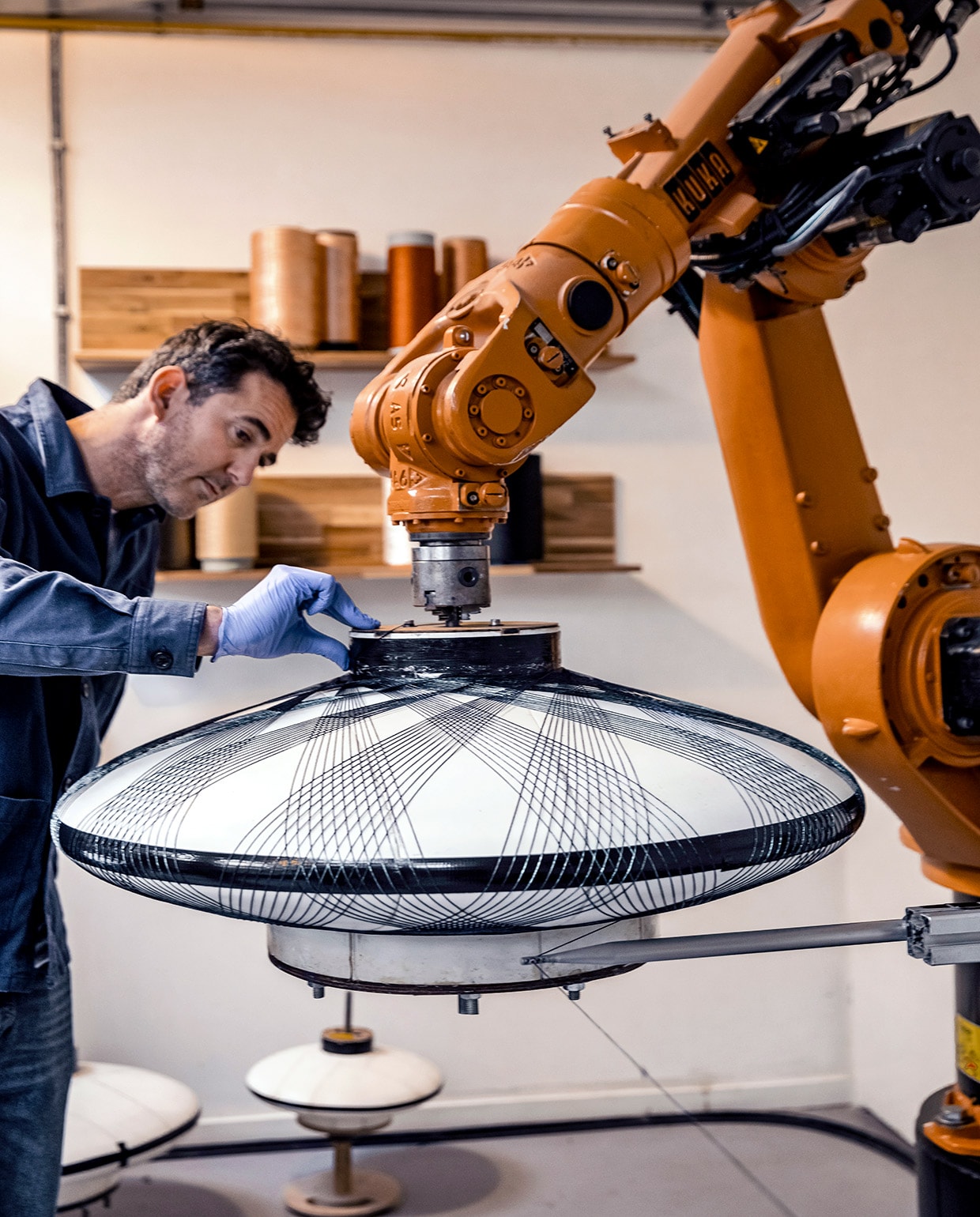 De Fiber Pattern Lamp is gemaakt van met epoxyhars geïmpregneerde vezels. De vezels worden met een industriële robot in geometrische patronen om een mal gewikkeld. Het resultaat is een lichtgewicht , en sterke lamp. Model Ufo is verkrijgbaar in diverse diameters en de kleuren Charcoal Black, Chalk White, Moss Green en Copper.