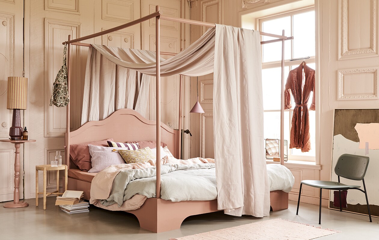 Bed, op maat gemaakt en geschilderd in kleur 86DI64 van D’Imago,180×210 cm prijs op aanvraag, tafeltje op hoge voet geschilderd in kleur 86DI64 van D’Imago, 75 cm (). Hemel Glenmoye van linnen in kleur Nougat van Designers Guild (wva.nl). Dekbedovertrekset van gewassen linnen in kleur Misty Green, 240×220 cm, dekbedovertrekset in Dusty Rose, 240×220 cm, kussenslopen in Clay Rose, 50×60 cm (yumeko.nl). Lampenkap Doris van HKliving, lampvoet, artwork, 100×120 cm, hanglamp mat paars, velvet kussen met paars-gele strepen, houten krukje met webbing zitting (hkliving.nl). Tas met print, linnen kussen Lilac Rose, kussen met bloemenprint in geel Lily Masala, roze vloerkleed Chindi Mat Rose, 60×90 cm (scandicliving.nl). Kussen met ruitprint, roomspray, karaf met glas van Ferm Living (letoile.store). Spiegel (jolandelijkdewebshop.nl). Fauteuil in groen Soft Edge 10 (vtwonen.nl).
