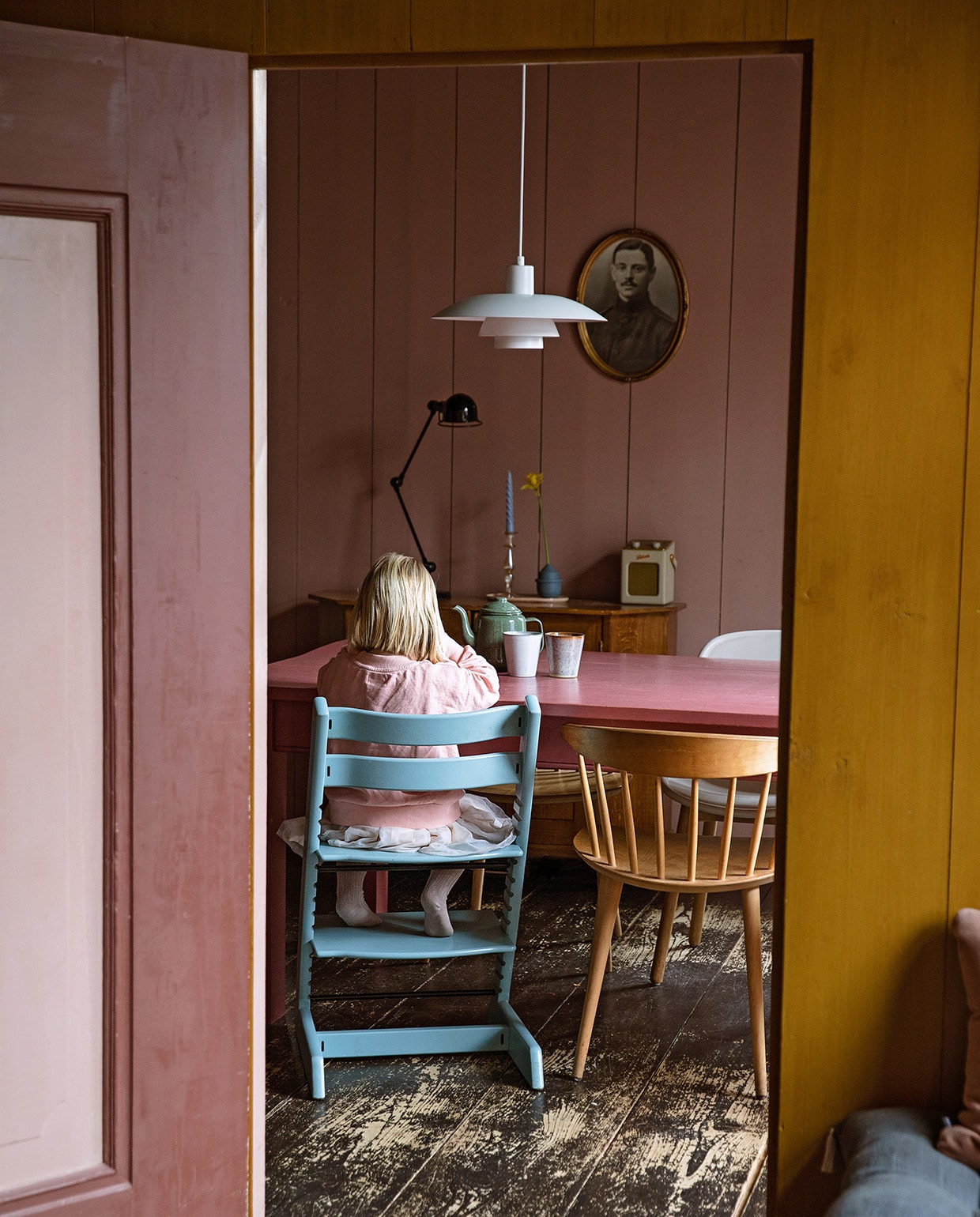 Bureaulamp Jieldé, kandelaar en groene kaars Anna + Nina. Blauwe kaars, tray, witte stoel en houten stoelen Hay. Kinderstoel Stokke. Blauw vaasje Mickey Philips, radio Roberts. Hanglamp Louis Poulsen. Tafel vintage, vaas en kopjes Sissy-Boy, theepot Dille &amp; Kamille.