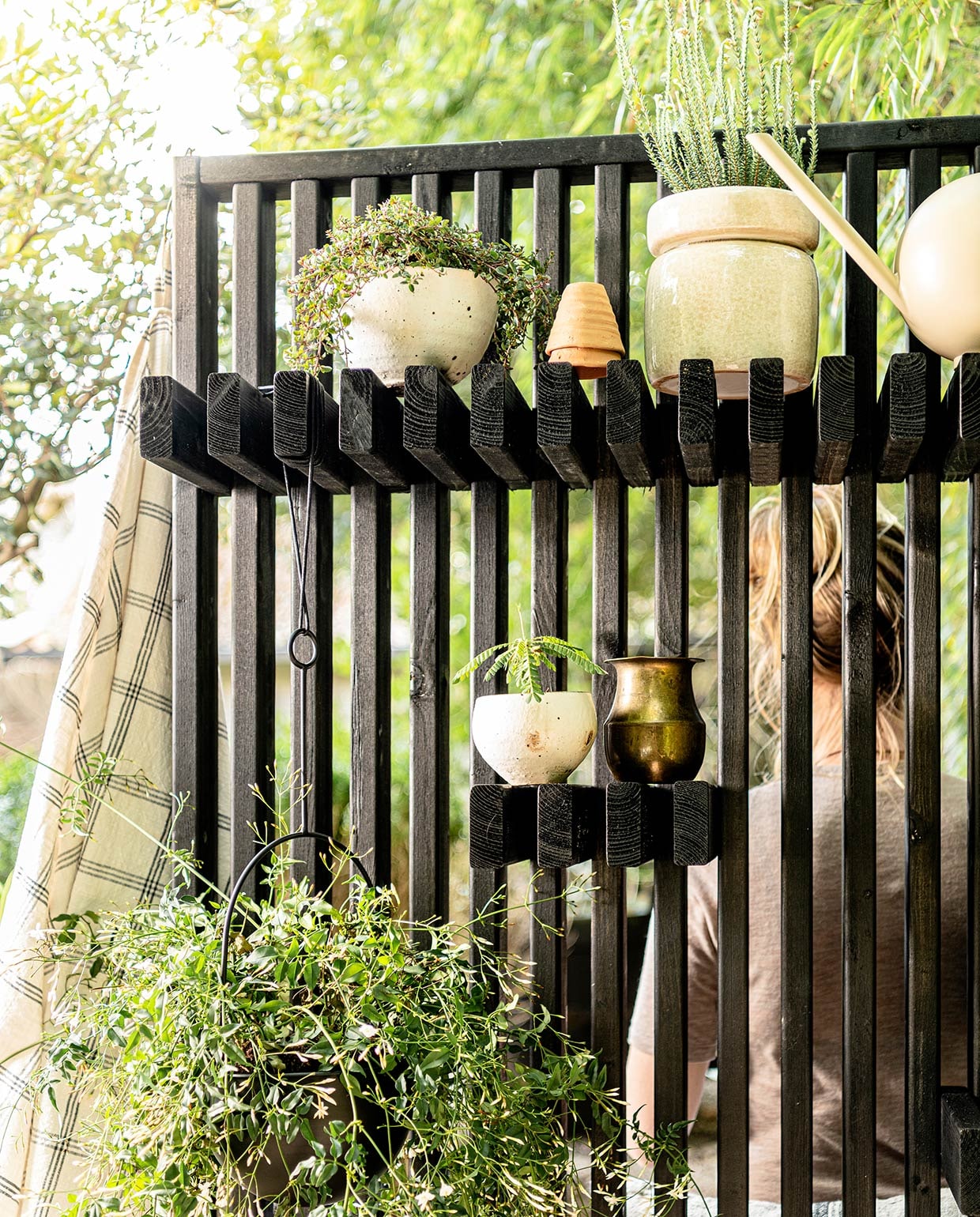 Katoenen geruit badlaken van Kyoto, bloempot met rand Isa (nordal.eu). Gieter Orb van Ferm Living (vtwonen.nl). Overige planten en potten (greenlifestylestore.nl).