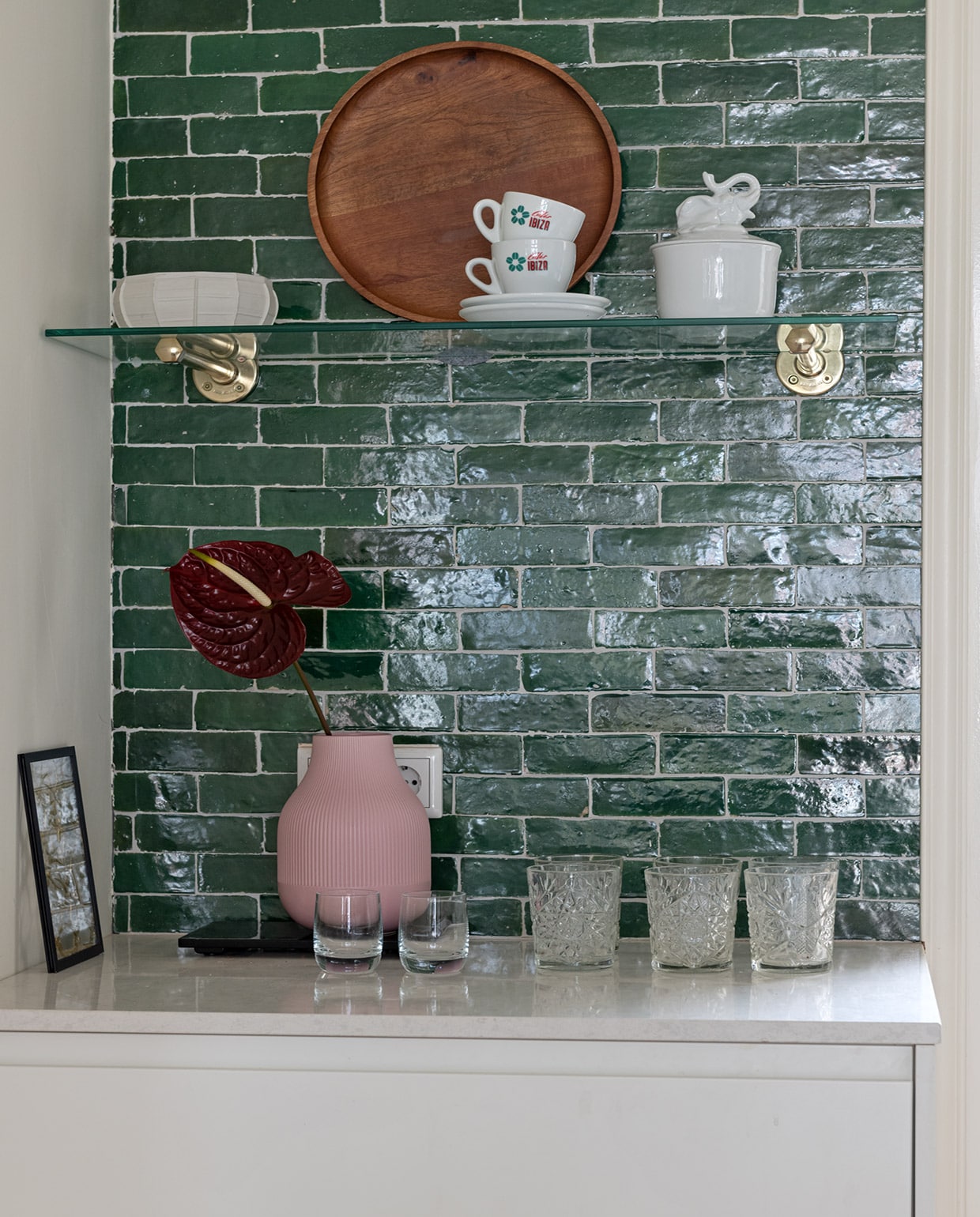 Tegels Bejmat in kleur Vert Foncee Designtegels. Porseleinen schaal Serax. Houten dienblad H&amp;M Home. Kop en schotel kringloopwinkel. Porseleinen schaal met olifant &amp;Klevering. Zwart lijstje Moebe. Roze vaas Ikea. Set whiskyglazen Glenfarclas Schotland. Glazen Libbey.
