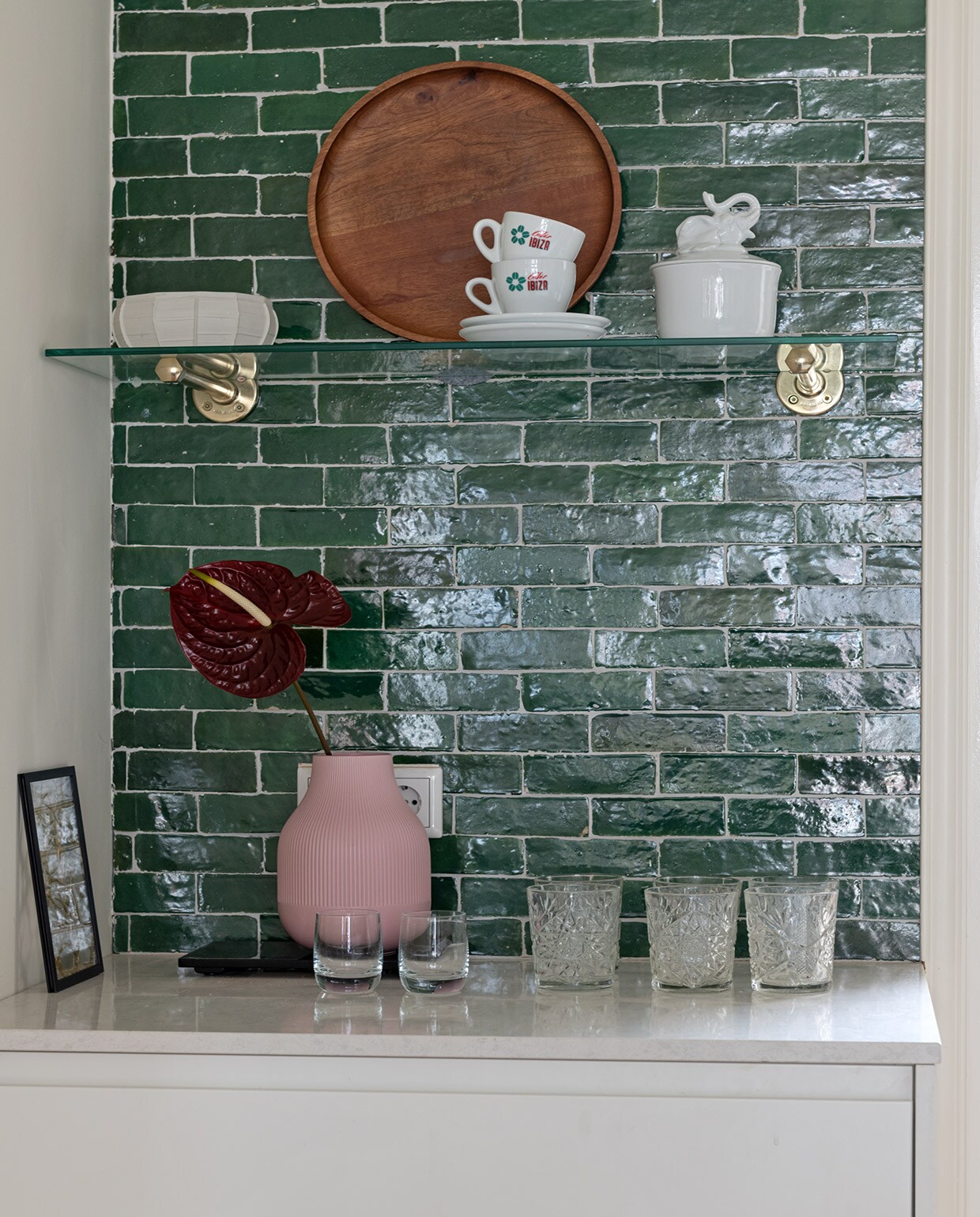 Tegels Bejmat in kleur Vert Foncee Designtegels. Porseleinen schaal Serax. Houten dienblad H&amp;M Home. Kop en schotel kringloopwinkel. Porseleinen schaal met olifant &amp;Klevering. Zwart lijstje Moebe. Roze vaas Ikea. Set whiskyglazen Glenfarclas Schotland. Glazen Libbey.