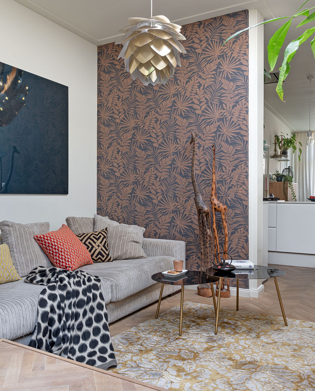 Muurverf Schelpenwit Histor. Behang Karwei. Visgraatvloer via BVA Auctions. Muurfoto Kaketoe PosterJunkie. Bank Basiclabel, kussens en plaid Conceptstore A La Loes. Vloerkleed Marcjanssen. Hanglamp Silvia Umage. Giraffen uit Afrika. Bijzettafels Eichholtz. Kop en schotel HKliving. Zwarte theepot kringloop.