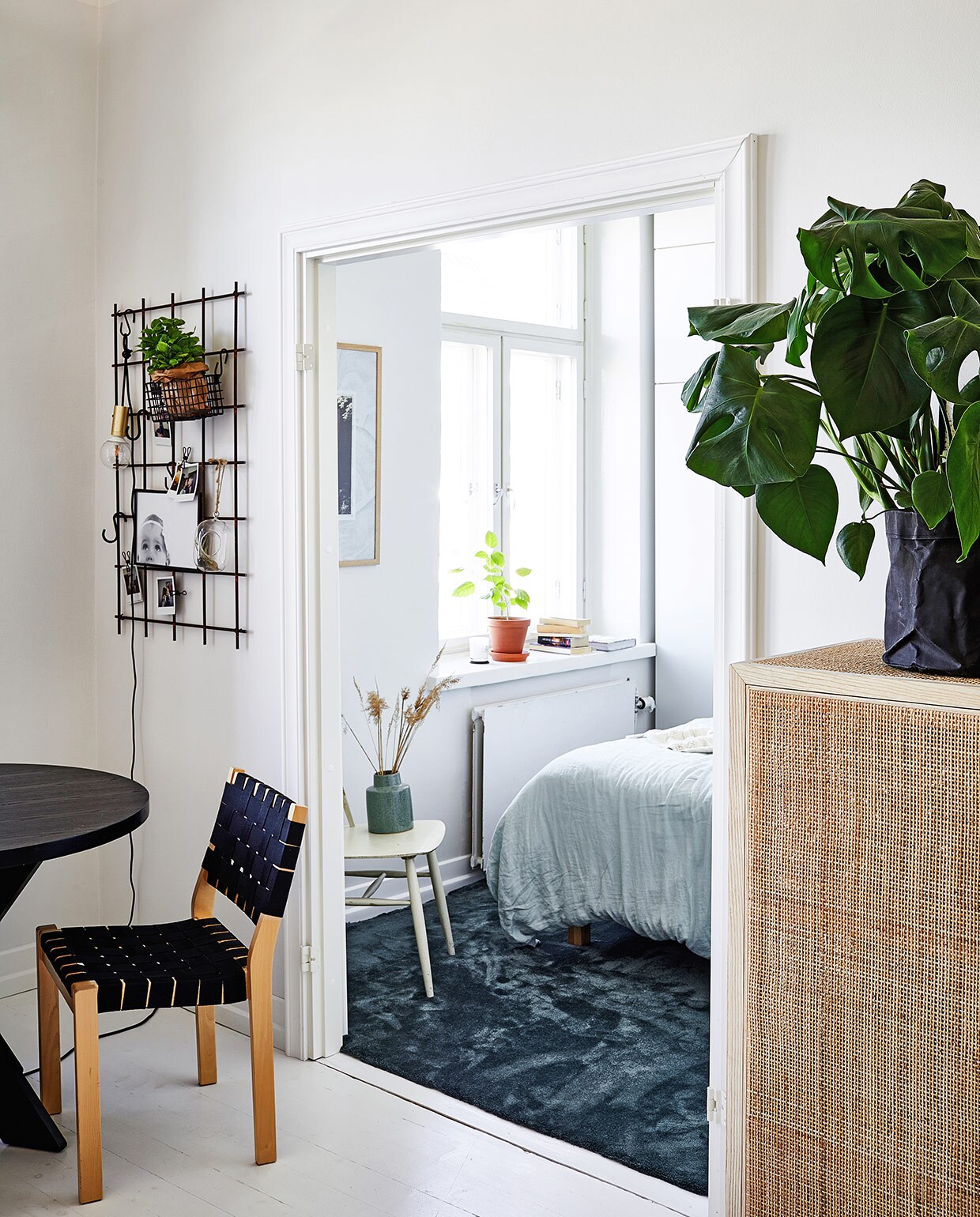 Tafel Jotex. Artek-stoel vintage. Betonraster van een bouwplaats als wandrek. Vaas Marimekko.Webbingkast Ikea.