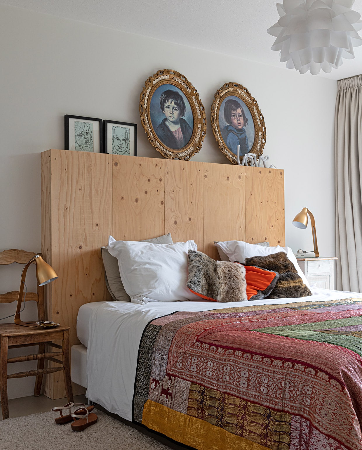 Muurkleur Ral 9010. Hanglamp en bed Ikea. Ombouw hoofdbord en tekeningen boven bed eigen ontwerp. Zigeunerschilderijen rommelmarkt, houten stoel antiekwinkel. Lampjes Barefoot van Leitmotiv. Kussens zelfgemaakt, sprei uit Portugal. Marmoleumvloer Walton van Forbo vloeren. Gordijnen Hema.