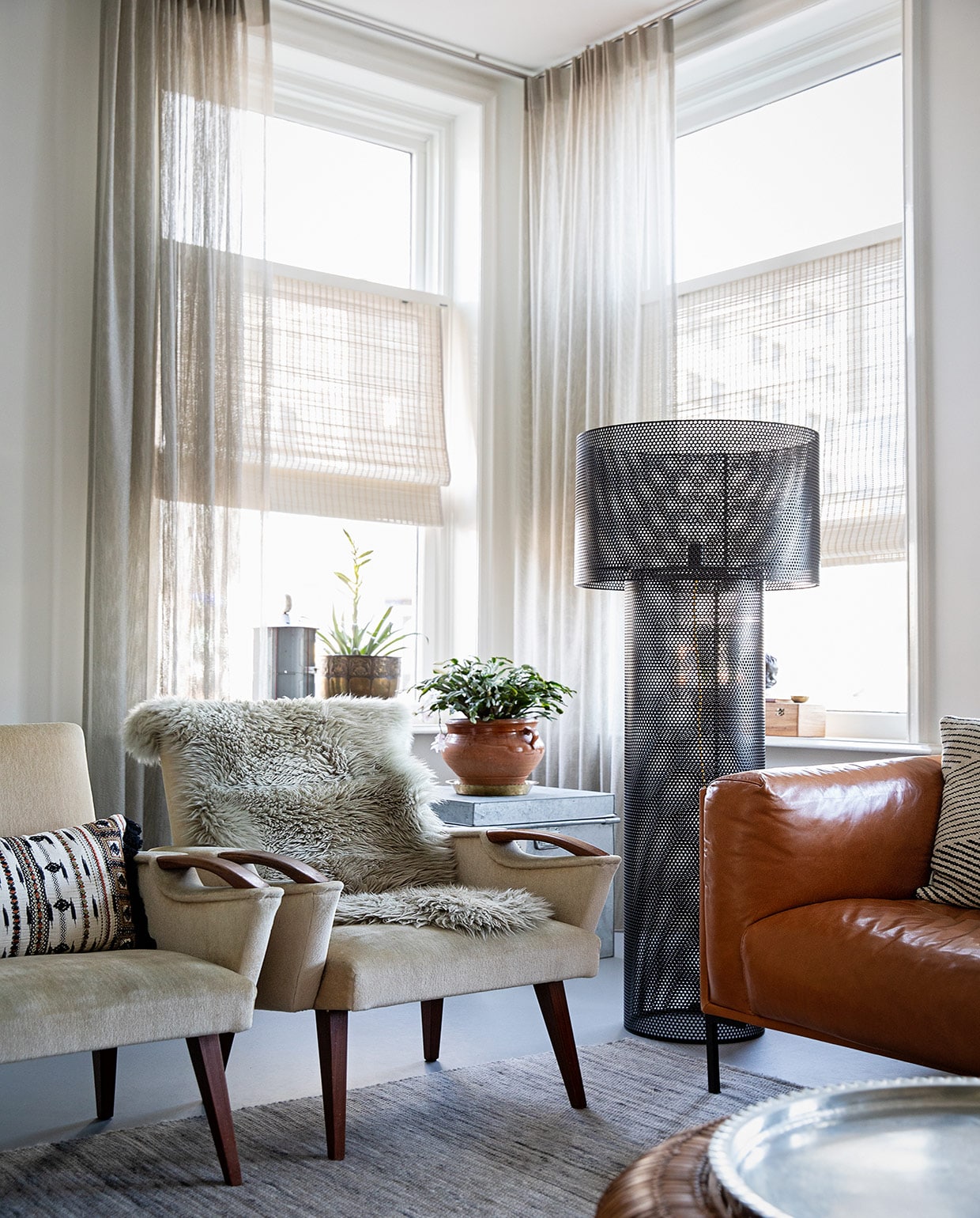 Muurverf Ral 9010 Flexa, gordijnen Sato van Jab Anstoetz, bamboe rolgordijn Sunway, fauteuils erfstukken, kussen op fauteuil Imbarro, dierenvel op fauteuil Karwei, bank Het Anker, zwarte staande lamp via Tica, koperen bloempot van grootouders, metalen blik van Franse antiekmarkt, houten kist cadeau, pot op kist kringloop, metalen kist Kleur op Kleur Interieur, vloerkleed via Woontheater , de Eclips. Hanglamp Ferm Living. Tafels Karwei.