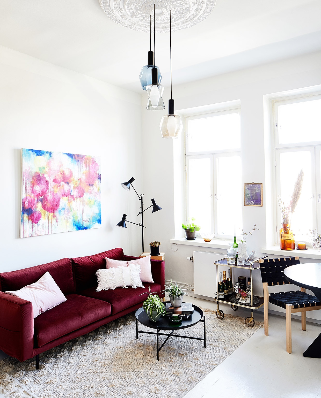 Schilderij Aino-Maija Laaksonen. Bank Hakola, kussens H&amp;M Home. Vloerkleed Anno Collection. Salontafel Ikea. Staande lamp Habitat. Hanglampen Tapio Wirkkala (Elisa’s oudoom!). Barwagen Fargo. Artek-stoelen vintage. Tafel Jotex.