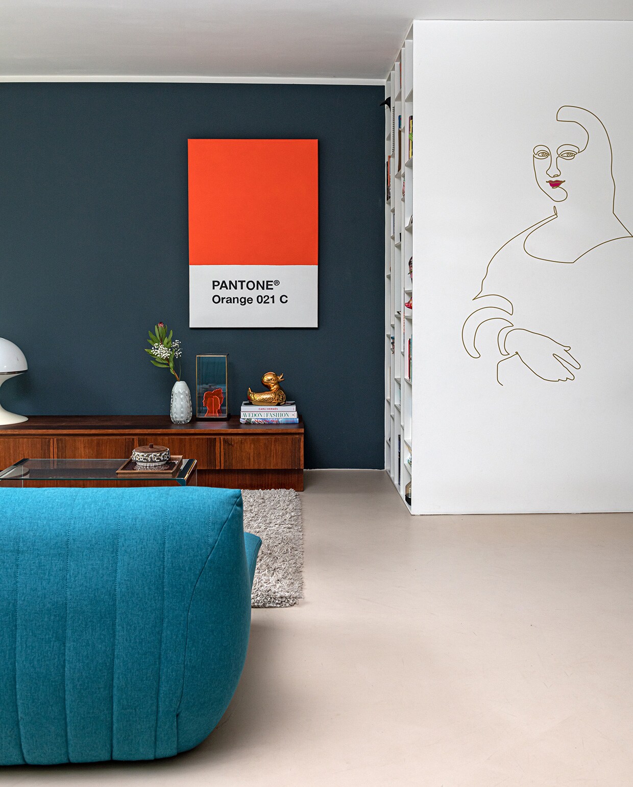 Pantone poster eigen ontwerp Charlotte, muurschildering Mona Lisa van oneline eigen ontwerp Michel. Glazen tafel Marktplaats. Bakje van keramiek vintage. Kleed Shaggy van Trendcarpet, bank Made, dressoir vintagevirus.nl, lamp Concept van Brabantia. Vaas kringloopwinkel. Portretten van acrylaat eigen ontwerp, in vitrine van HKliving. Eendje Jasmin Djerzic. Kast eigen ontwerp, productie interieurbouw Niels Breuer.
