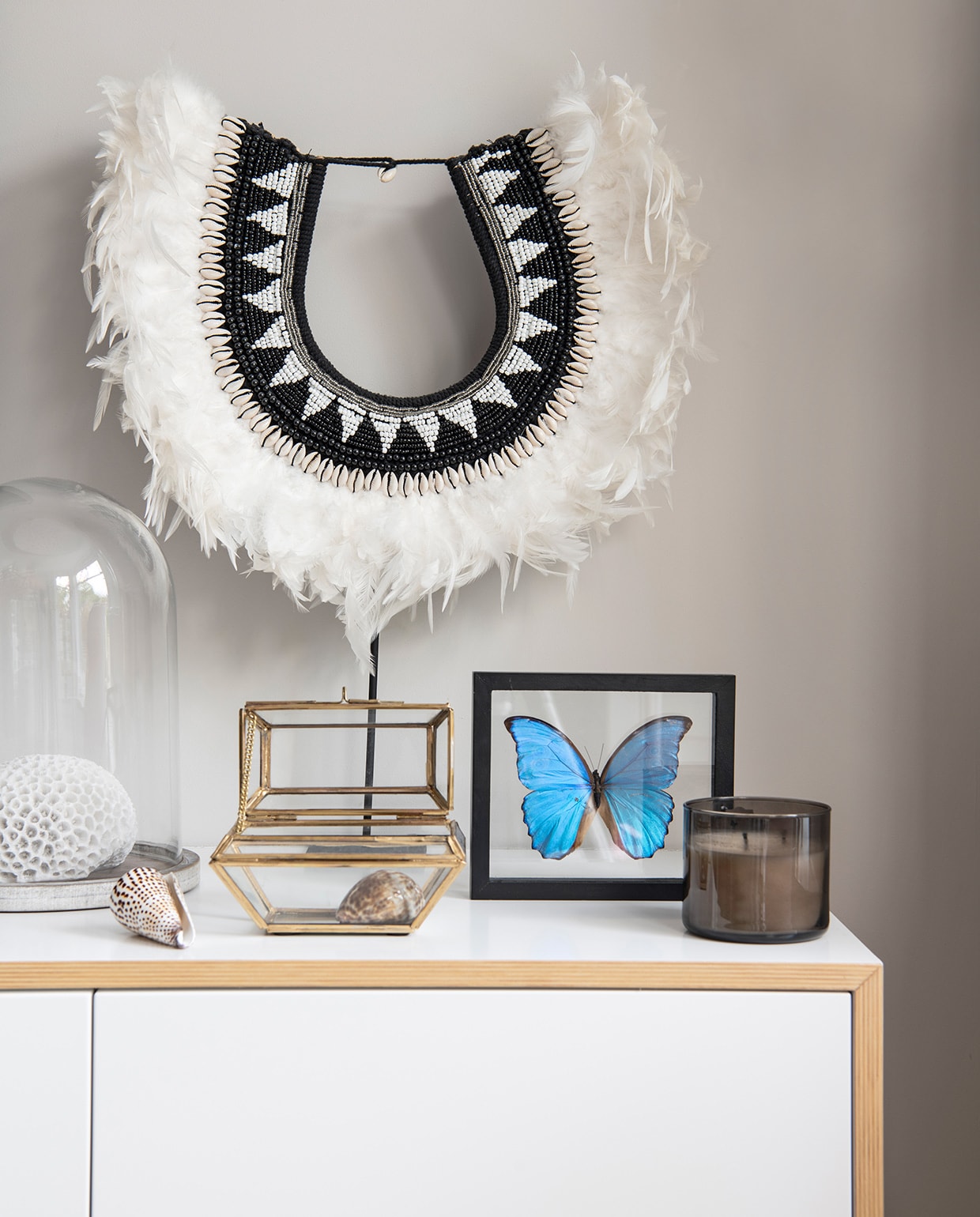 Ketting met veren Koya Living. Pot Nunc Amsterdam. Vlinder gekocht in Peru. Vitrinedoosje Sissy-Boy. Kaars Bath and Body Works. Kast op maat gemaakt door Mint Interiors.