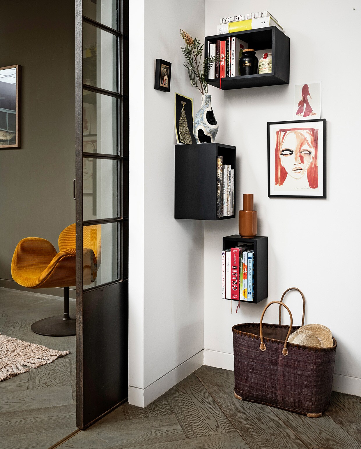Kasten Stacked van Muuto, vanaf 21,8x35x43,6 cm (bxdxh), vaas met dessin van Hay, terra vaas van Woud, fauteuil Tulip in specerijgeel ribcord van Artifort (eijerkamp.nl). Kunstwerk Red portrait van LouLou Avenue (papercollective.com). Raffia tas (basketbeadsbasics.nl). Hoed (scotch-soda.com). Loper van Ferm Living (misterdesign.nl). Overig privébezit.