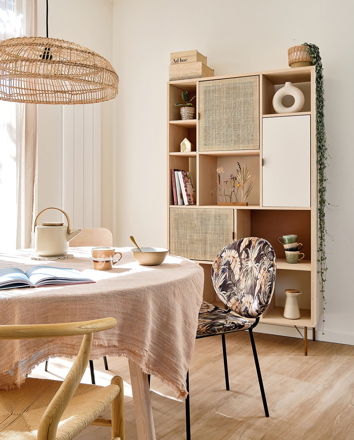 Houten stoel Sklum. Stoel met print Kwantum. lamp en tafelkleed HKliving. Theepot Stelton via fonQ. Kop en schaaltje HKliving. Kast Maisons du Monde. Kistjes Bloomingville. Plant in pot fonQ. Cirkelvaas H&amp;M Home. Huisje Bloomingville. Droogbloemen Bloomon. Mokken HKliving. Koffiemaker Stelton.