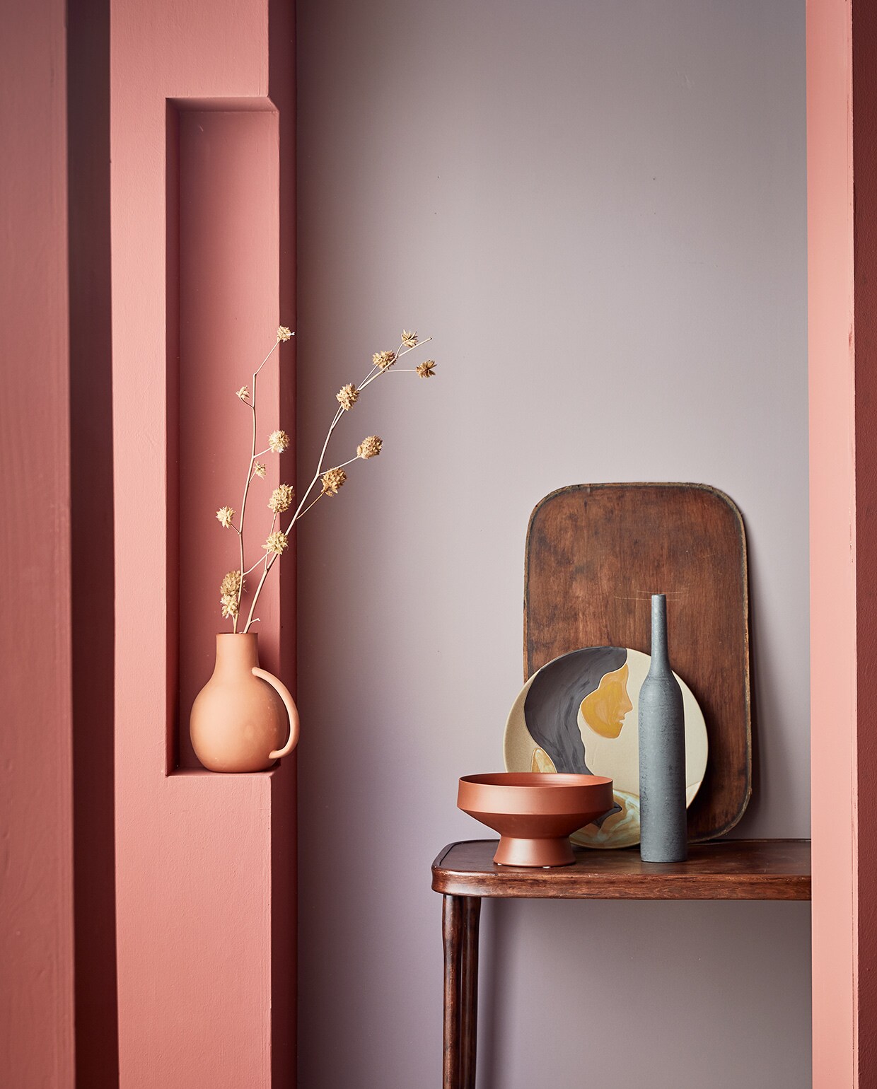 Muurverf op kolom Red Earth, op achterwand Washed Lilac. M.m.v. nordal.eu (vaas met oor, terracotta schaal) vtwonen.nl (bord met opdruk van Ferm Living). Overig privébezit.