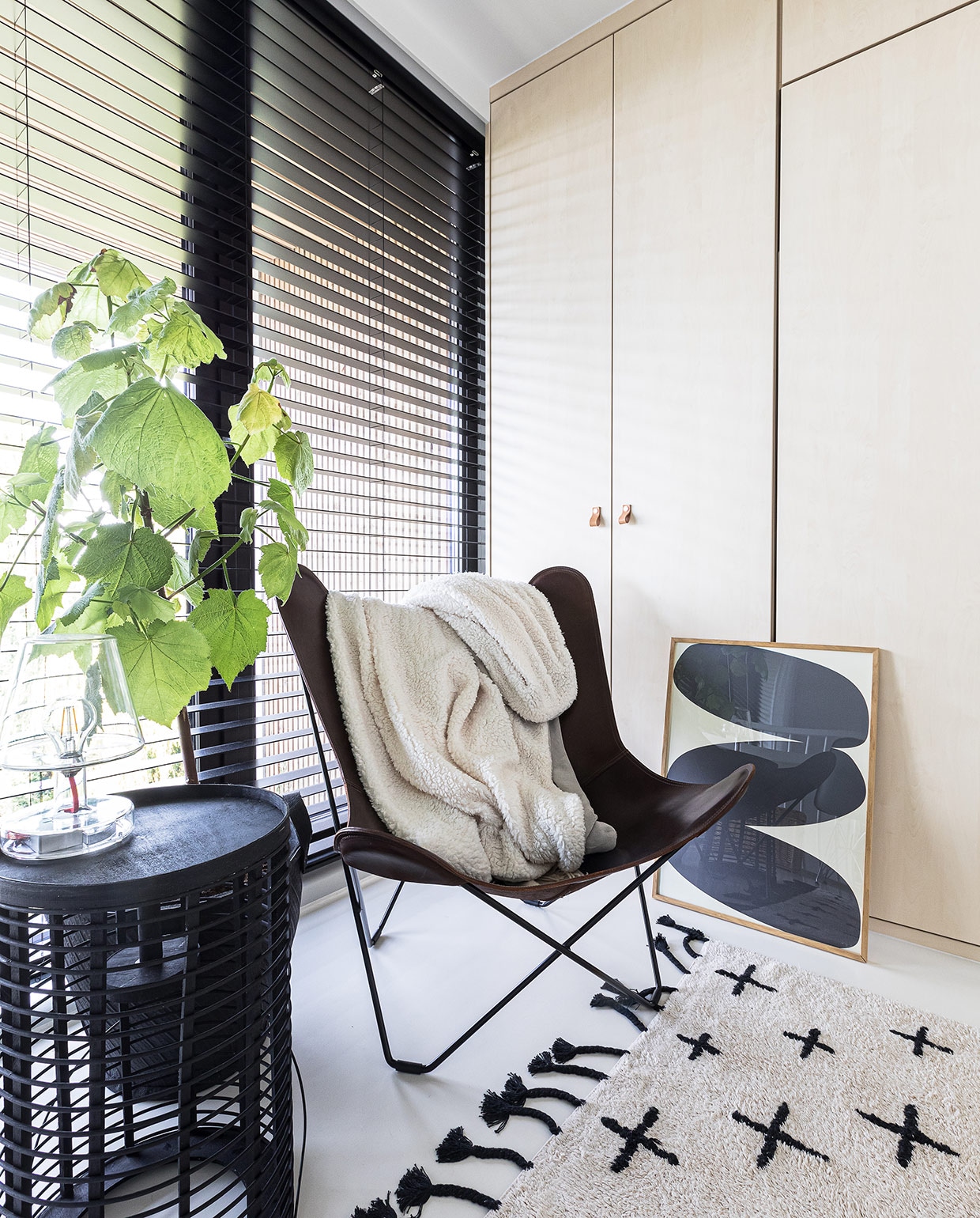 Inbouwkast op maat gemaakt Signaal Interieur &amp; Wonen. Vloerkleed vtwonen. Zwarte lantaarn als bijzettafel Yaya. Glazen lamp Fatboy. Vlinderstoel Studio Ambacht. Plaid Intratuin. Grafische print Paper Collective. Rubberen bloempot Loods 5.