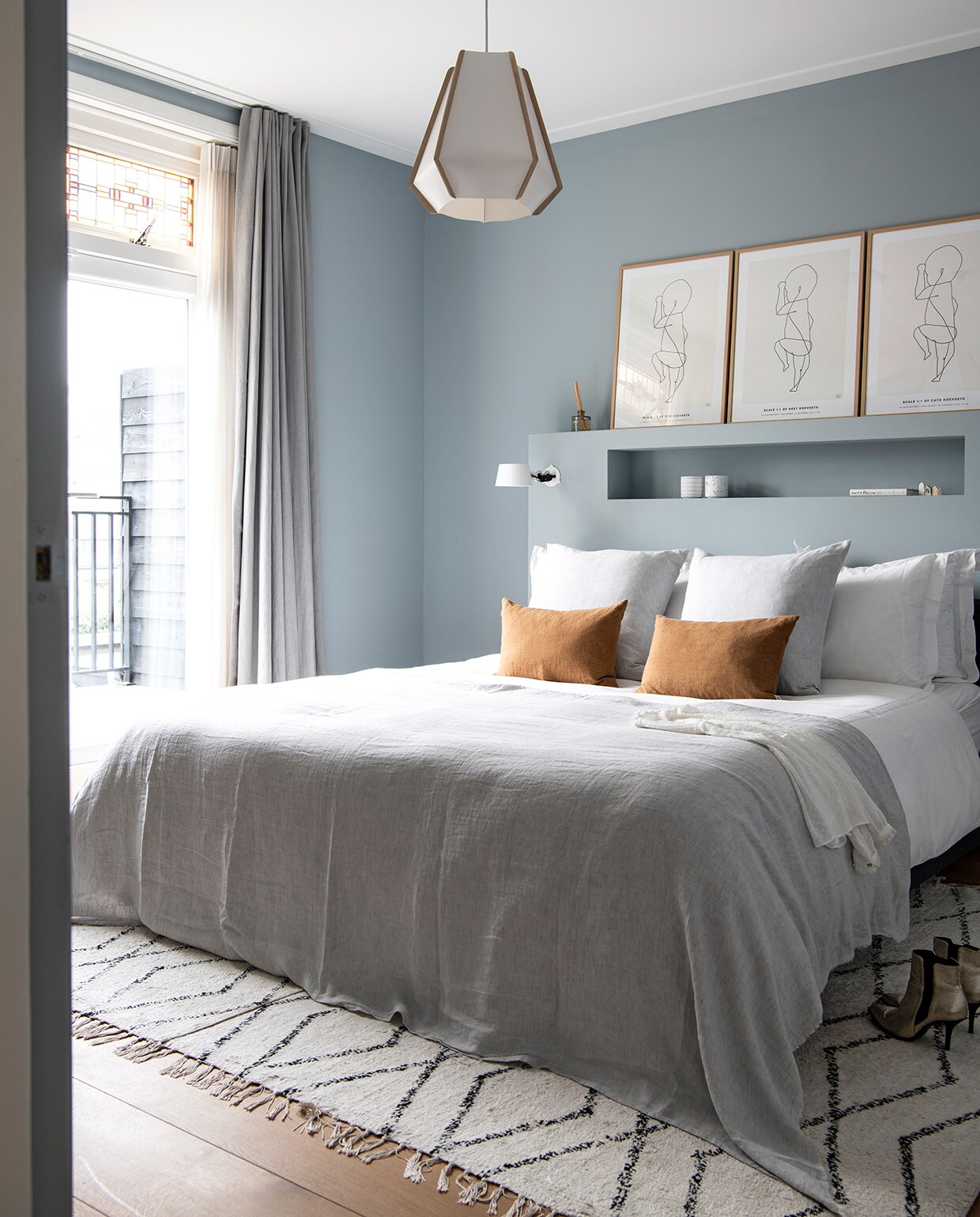 Muurverf Bone China Deep Blue 184 van Little Greene. Linnen gordijnen, bruine kussens, grijze kussens en grijze sprei By Mölle. Beddengoed Zara Home. Hanglamp Lullaby Lightyears. Nachtlampen Bolt van Tonone. Posters The Birth Poster. Vloerkleed HKliving. Waxinelichthouders Fest.