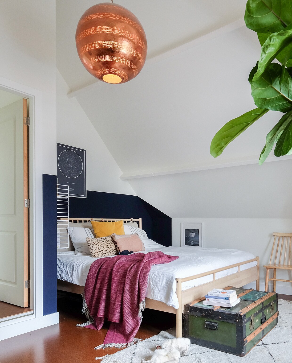 Bed met hoofdbord en vloerkleed Ikea. Kist van Oscars opa. Rendiersloffenuit Lapland. Poster The Night Sky. Beddengoed H&amp;M Home. Hanglamp uit India. Houten stoel Tressia van Kave Home.