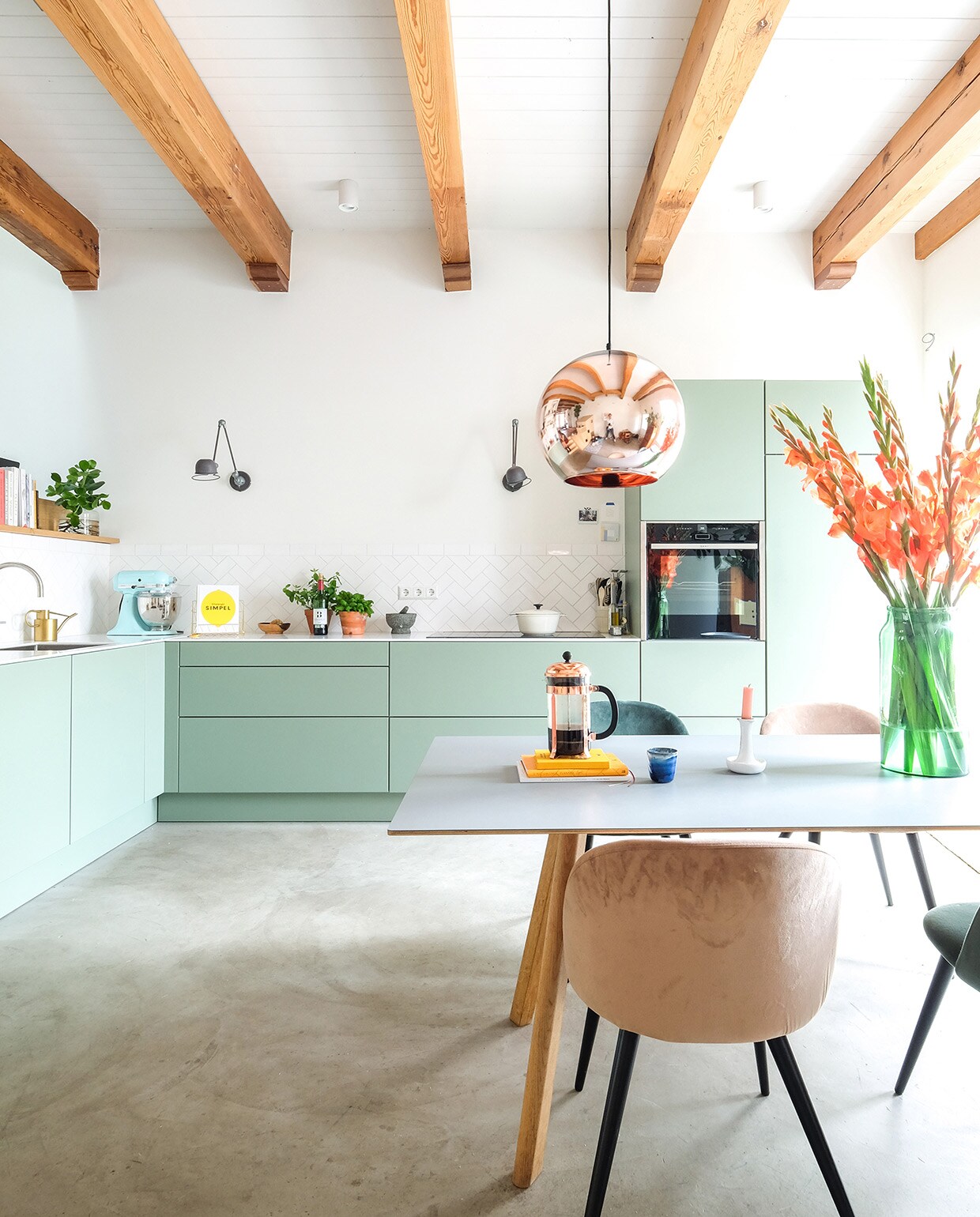Keuken Next125, kleur Sage. Tafel Hay. Hanglamp Tom Dixon. Herkomst stoelen onbekend. Vaas Bloemetje Op Tafel. Kandelaar Hay. Cafetière Bodum. Pan Ikea. Wandlampen Lucide. Keukenmachine KitchenAid. Kraan Quooker. Schappen Ikea.