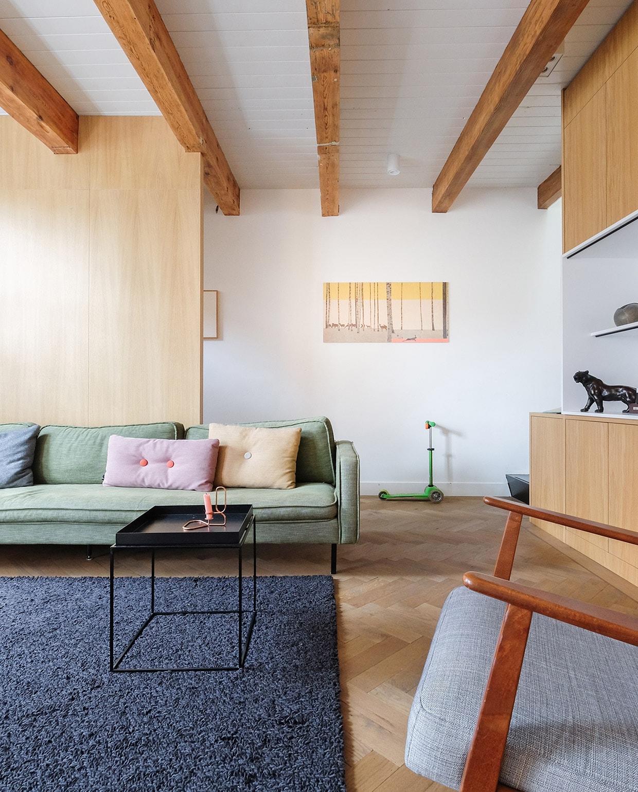 Bank Loods 5. Kussens en bijzettafel Hay. Scheerwollen kleed Marktplaats. Zwarte panter familiestuk van Oscar. Berkenhouten wandpaneel met illustratie van StoryTiles. Fauteuil Ikea. Stepje Microstep.