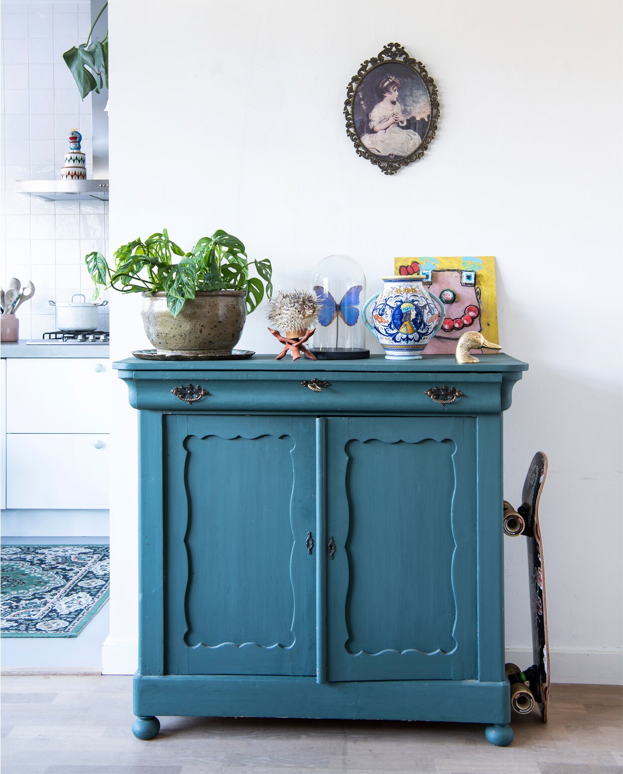 Kast van kringloop, zelf geschilderd met verf vintage paint Forest Green van Jeanne d’Arc Living. Bloempot tuincentrum Het Oosten. Kogelvislamp Hutspot. Vlinder in stolp De Museumwinkel. Oude vaas van Kims opa en oma. Eend souvenir uit Lissabon. Kunstwerk van Pleun, geïnspireerd door Karel Appel. Lijst op de muur Fortune Flea.