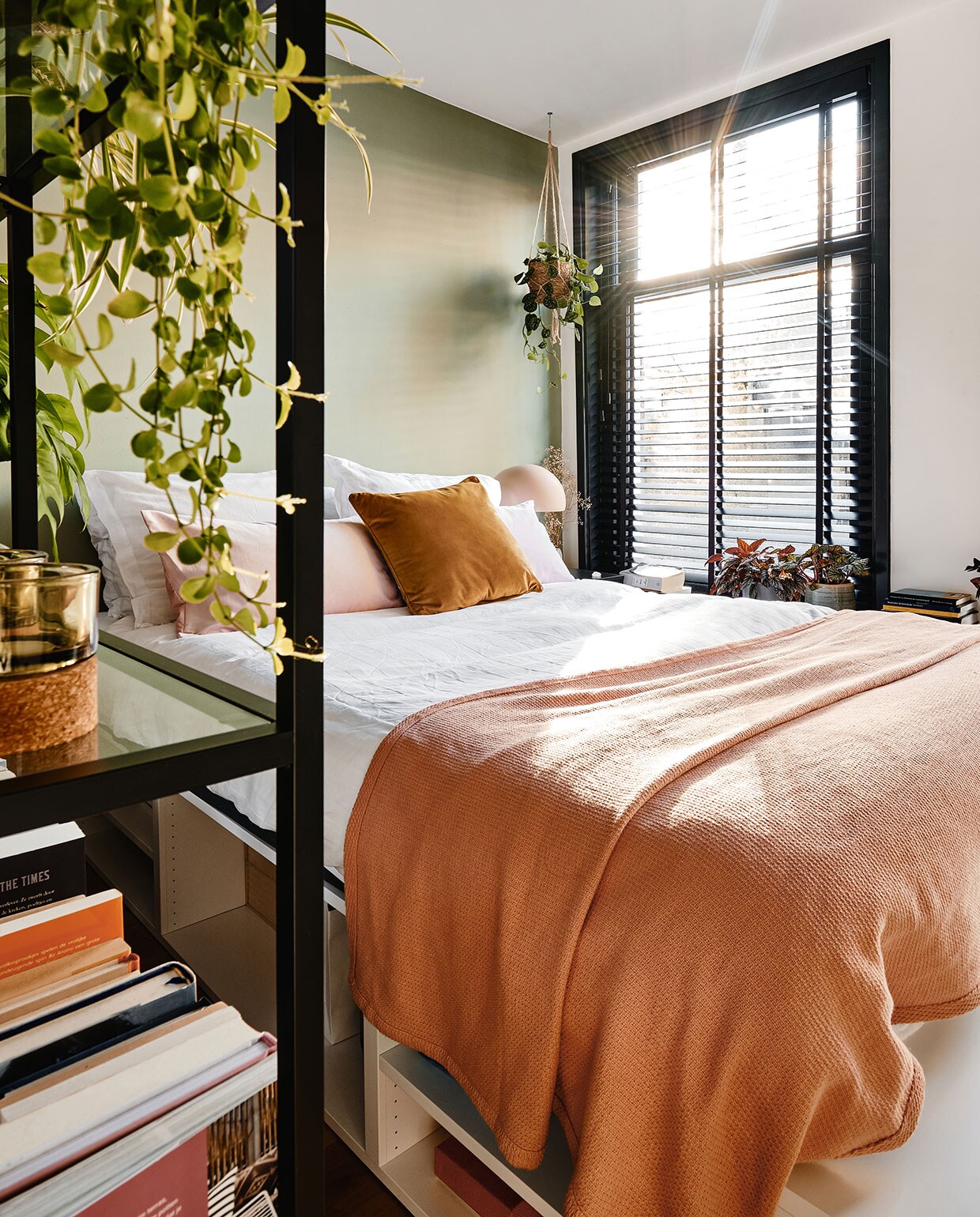 Bed, kussens en vakkenkast Ikea. Beddengoed Hema, sprei Made. Hangplant, bloempot, waxinehouders De Balkonie. Nachtlamp Made.