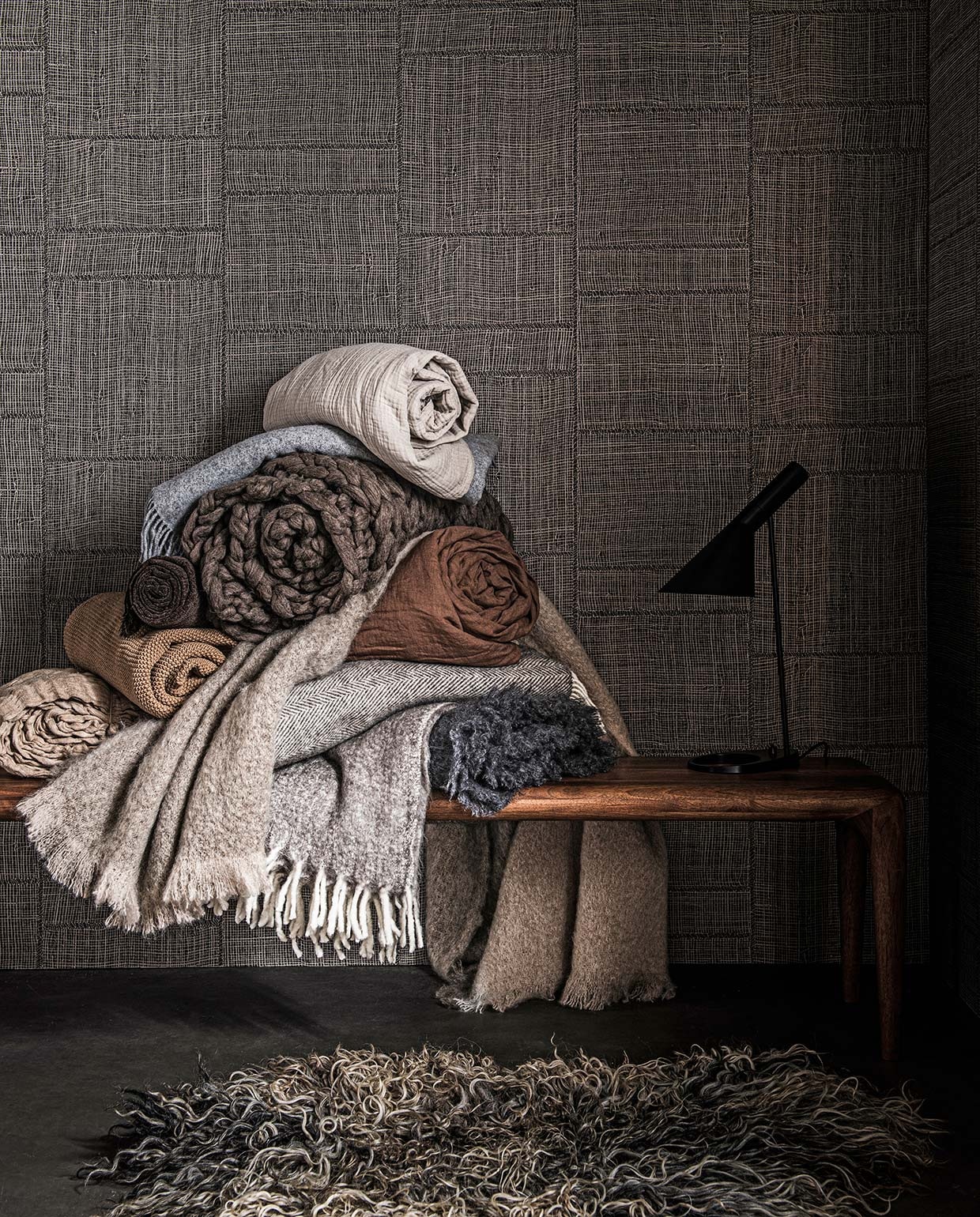 Vloer vtwonen Novilon Kwarts, 200 of 400 cm breed, per meter vanaf € 56,50 (vtwonen.nl). Behang Twine in kleur Warm Steel uit Cameo collectie, 0,70×8,5 m (bxl), per rol € 199,- (arte-international.com). Walnoothouten bank €1282,-, tafel- lamp € 790,- (kasstoor.nl). Schapenvacht € 189,- (vachtvanvilt.nl). Dekens van boven naar beneden: zachtgrijze plaid € 69,99, grijze deken met witte rafels € 29,99, bruine gehaakte deken € 49,99, beige deken met reliëf € 99,- (hm.com). Wollen deken € 89,99, bruine linnen deken € 169,- (zarahome.com). Grof wollen deken € 279,- (vachtvanvilt.nl). Beige mohair deken €195,- (coosdewitwonen.nl). Deken met visgraatprint, € 199,-, antracietgrijze mohair deken € 199,- (bymolle.com).