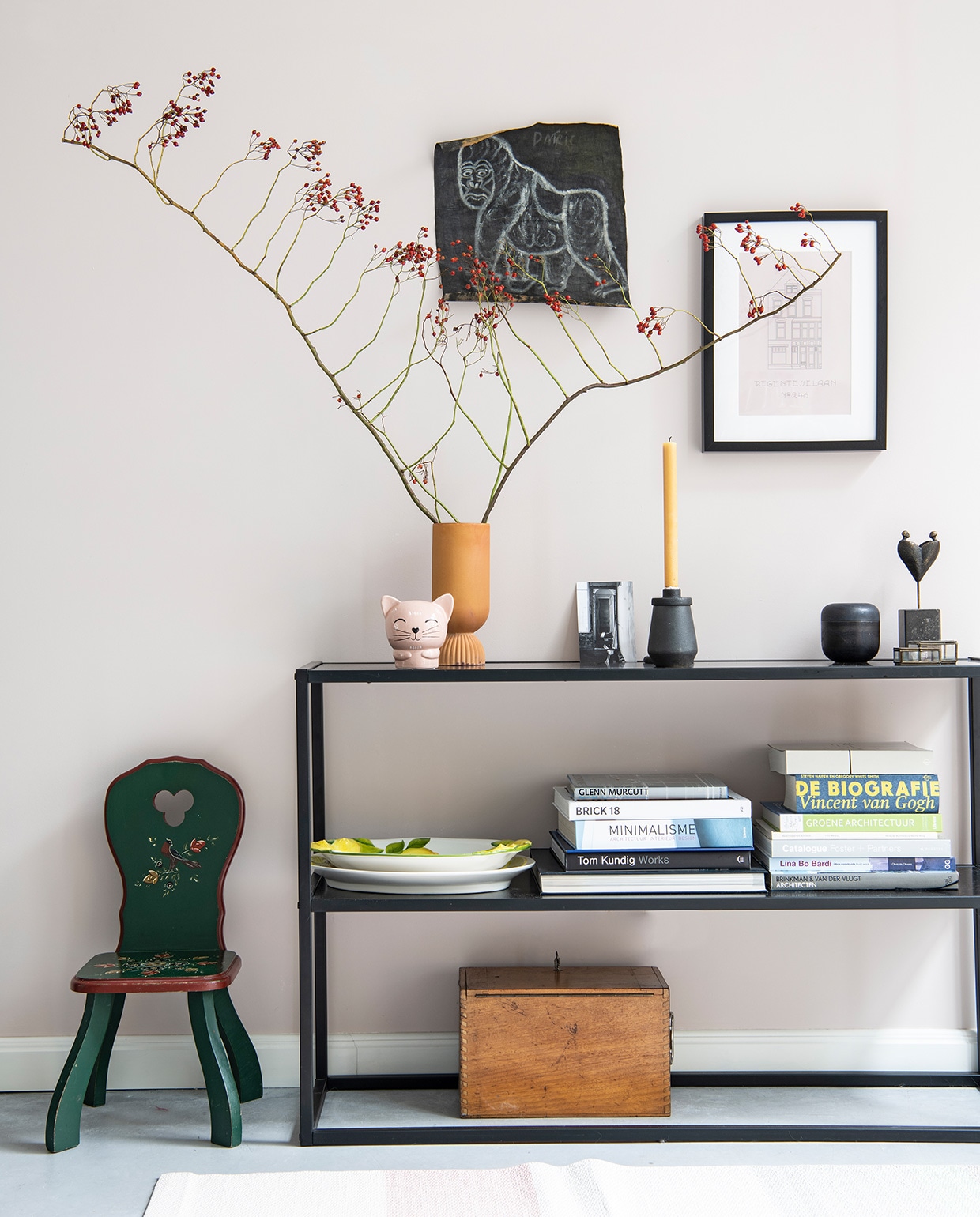 Groene kinderstoel erfstuk, sidetable Karwei. Houten kist en glazen doosje vintage, vloerkleed Hay, vaas HKliving, roze kat Hema, herkomst zwarte kandelaar onbekend, schalen souvenir uit Italië, beeld van Monique Bruls. Schets aap souvenir uit Oeganda, print huis gemaakt door Britt. Muurverf E0.05.75 van Flexa.