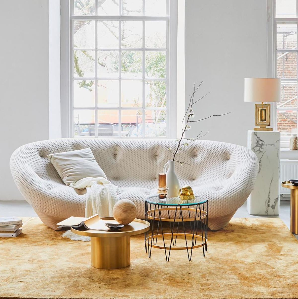 goud inBank Aikon Lounge, inclusief armsteun (designonstock.com). Vloerkleed van Louis de Poortere uit de serie Mad Men (vloerkledenwinkel). Salontafel marmerlook, 40,6×100 cm (hxØ), rond kussen, goudkleurig velvet kussen (polspotten). Loungestoel velvet, plaid , witte vaas met oor, kleinere vaas van Loods 5 Design (loods5). Hoge vaas, staande lamp (hkliving). Beige Poef Sandared, grijze poef, lijst Hovsta (ikea). Lamp op marmeren schouw (maisonnl.com). Lamp in vensterbank (dutchbone.com). Vaas met oren (neeflouis). Kandelaar op tafel (vtwonen.be). Overigprivébezit.terieur vtwonen 02-2019 | styling Cleo Scheulderman | fotografie Jeroen van der Spek