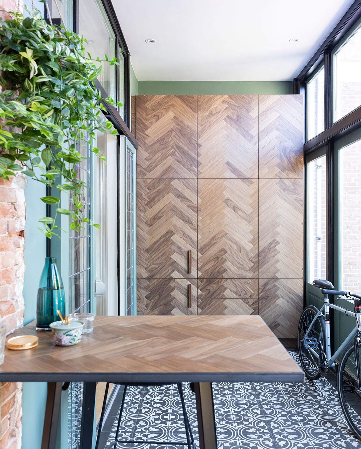 Hoge bartafel onderstel van Hay met massief eikenhouten blad gemaakt door SkillsXL, blauwe waterkan en waterglas Ikea, Portugese vloertegels Designtegels.