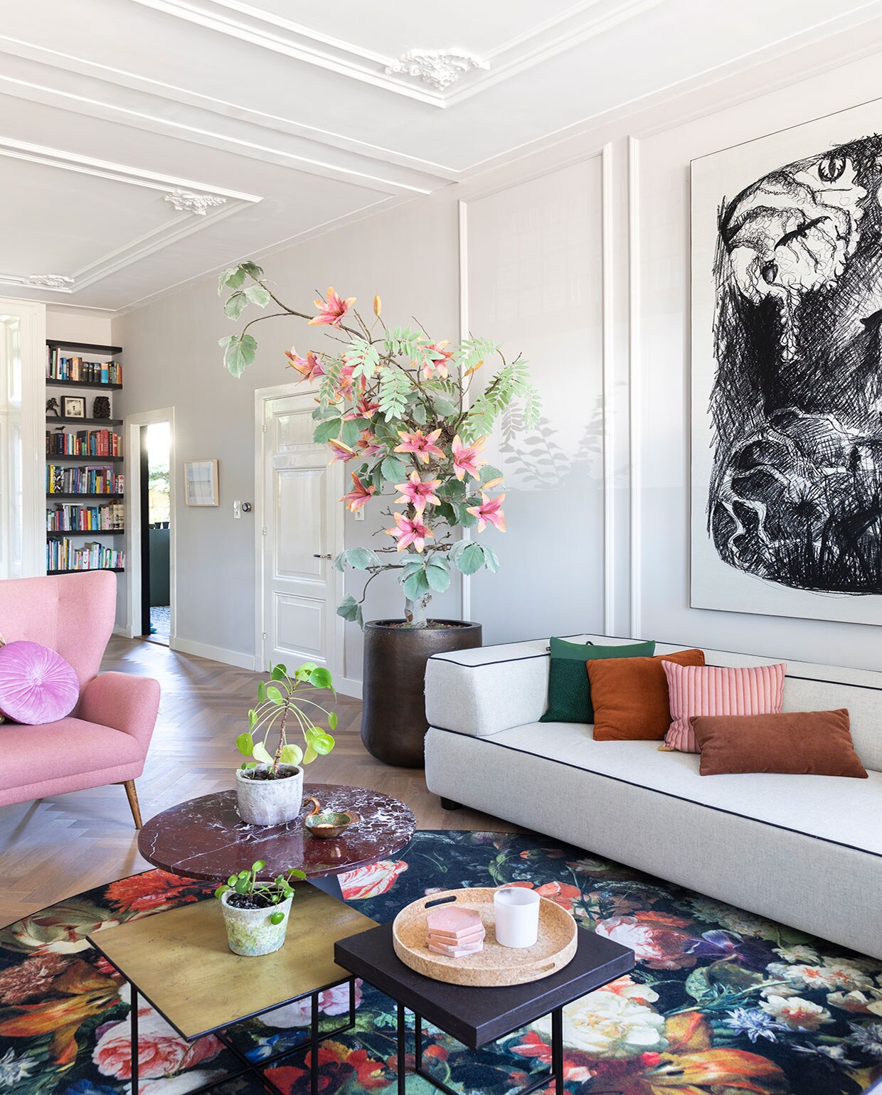 Muurverf Cornforth White, massief eikenhouten visgraatvloer via Martijn de Wit Vloeren, boom ’s Zomers Bloemen, pot Domani, marmeren bijzettafel Westwing, pot Dekatuin, schaaltje op tafel Anna + Nina. Fauteuil Sofacompany, kussens op fauteuil Essenza, wandplanken waren al aanwezig, geverfd in Pitch Black van Farrow &amp; Ball. Bank Fest Amsterdam, vloerkleed Moooi.