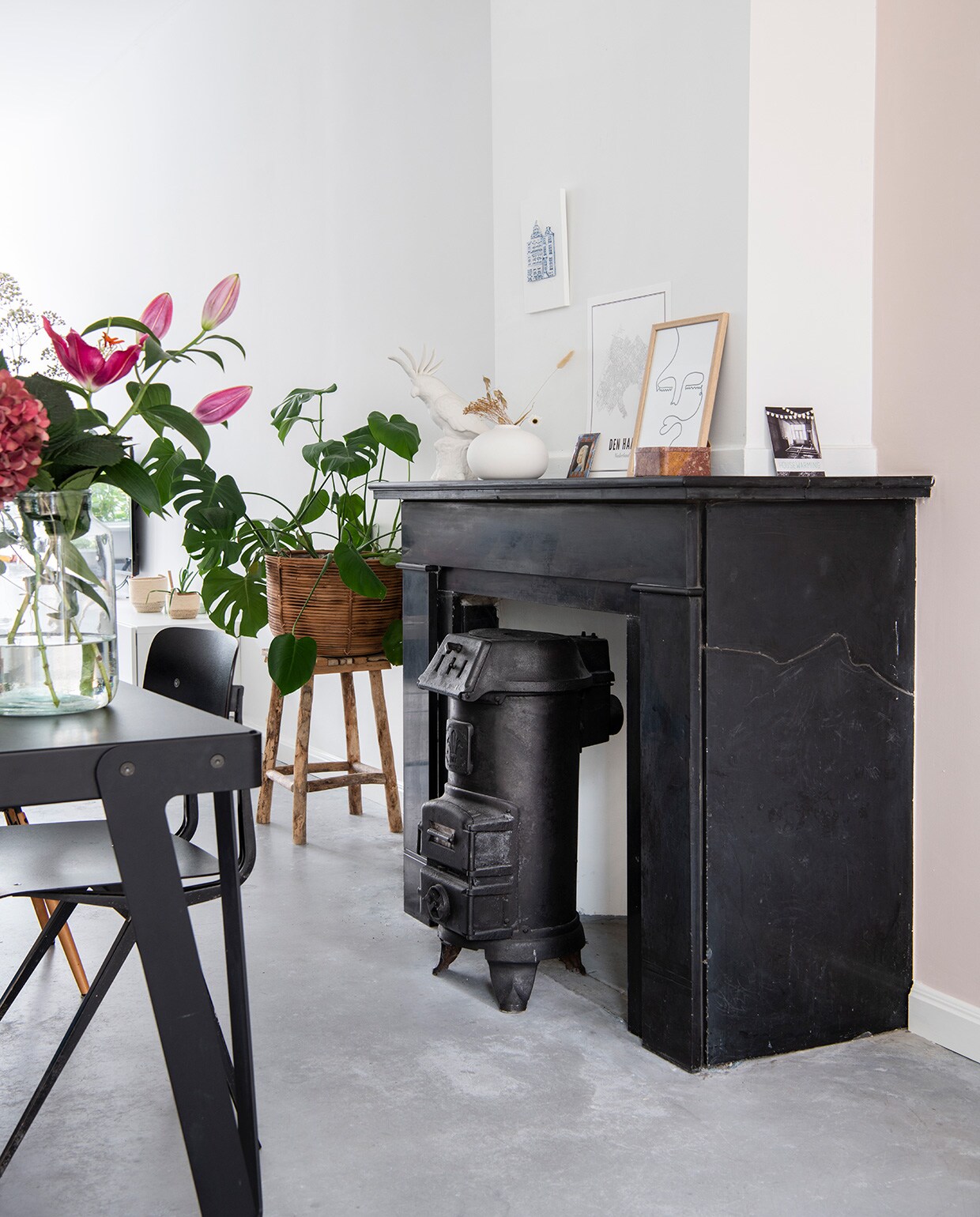 Open haard en gietijzeren kachel zaten al in het huis. Kaketoe Pols Potten. Vaas Urban Nature Culture. Print huizen Alexandra Breeze Ceramics, kaart van Wijck, print gezichten Studio Lisa. Houten doosje vintage, foto van een schilderij dat Britts tante van haar maakte.