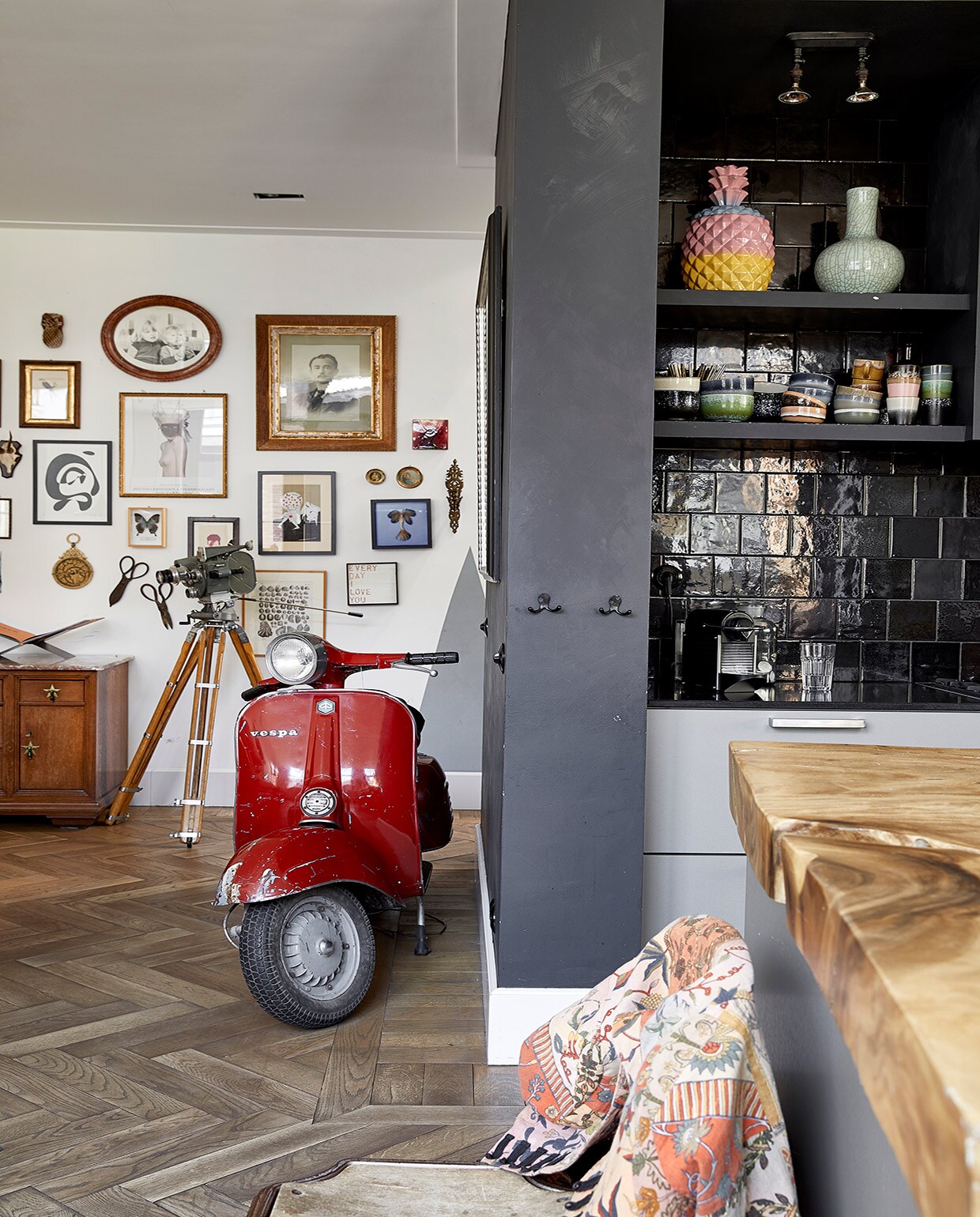 Muurverf Leliewit van Histor en Graphite van CarteColori. Vloer groothandel. Scooter gekregen van Richards vader. Kast Van Dijk &amp; Ko, boekenstandaard Mendo. Camera boedelverkoop. Aan de muur v.l.n.r. Ananas Anna+Nina. Schilderij met vogel Venduhuis de Eland. Ronde lijst Amsterdam Yard Sale. Ingelijste foto uit boedelverkoop. Rode tegel tweedehands. Zwart-wit schilderij Cate Adriana. Ingelijste poster Inez &amp; Vinoodh via Moam. Schilderij op karton Kunsthaus Tacheles. Ronde werken erfstukken. Blauw werk zeemeermin gekocht van bovenbuurvrouw. Kandelaar kringloop. Zonnewijzer gekocht in Marokko. Lijst met vlinder Stenelux. Scharen boedelverkoop. Werk David Bowie Moma Londen. Print schelpen gekregen. Print Anna+Nina. Vazen in de keuken Pols Potten. Servies HKliving en vintage. Wandtegels Piet Jonker