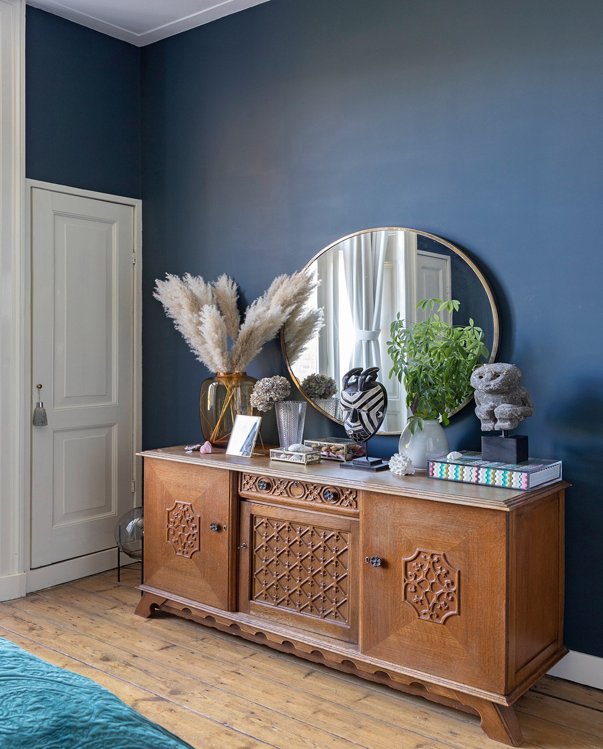 Muurverf Hague Blue Farrow &amp; Ball, originele vloer uit 1889, hanglamp Flos, bed Auping, nepplant Strelitzia en pot Jasmijn Bloembinders, wandlamp Karwei, blauwe vaas HKliving, vogel Toikka Iittala, fotolijst van Christians ouders geweest, beddengoed bloemenprint, wollen plaid, paars kussen en rond kussen Essenza.