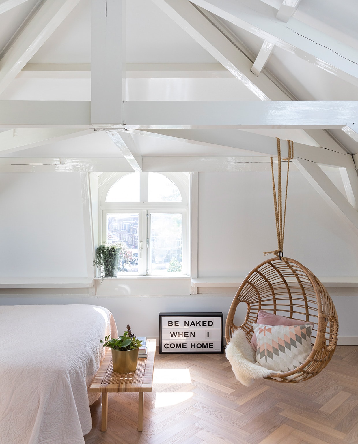 Massief eikenhouten vloer via Het Vloerenhuys, bed Swiss Sense, sprei Essenza, soortgelijke hangstoel