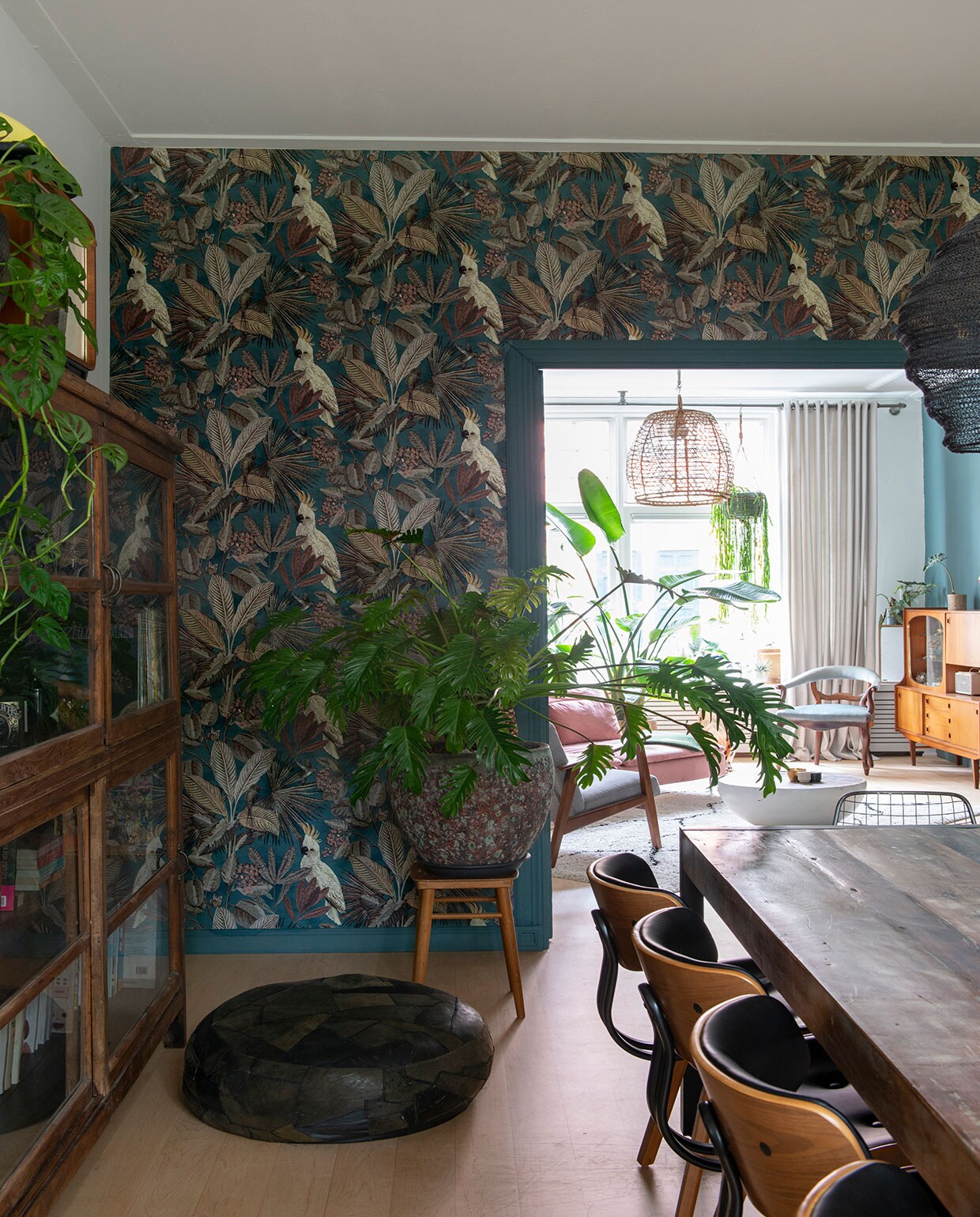 Bank en grijze fauteuil , bankhoes Norsemaison. Groene plaid, kandelaars op tafel  Vloerkleed . Salontafel van een designveiling. Plafondlamp . Platenspelermeubel, vaas op schouw, blauwe stoel en kast vintage vondsten, soortgelijke kast @trashuresnl. Plantenpot met cactus op schouw . Zwart beeld en minivaas aan muur vintage Cortendorf. Vintage pot met hangplant String of hearts. Muur- en lakverf van Farrow &amp; Ball. Grote plant Strelitzia, pot . De esdoornhouten vloer lag er al. Gordijnen . Behang Toekan , plant ervoor vingerplant. Paneeldeuren Stichting Monument &amp; Materiaal.