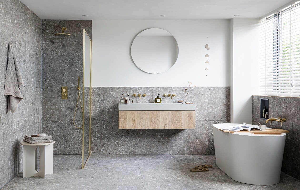 Vrijstaand bad Tub in kleur Powder White, 165x72x60 cm(lxbxh) € 3085,-, badplank Board in blank eiken, 78×27 cm(lxb) € 275,-, badthermostaat Grip met hendels in kleurBronze € 895,- (ook in kleuren Black Steel, Brushed, Charcoalen Chrome). Wastafel onderkast Cube van eikenfineer inkleur Oak, met 1 lade, 30x120x43,5 cm (hxbxd) € 519,-(ook in kleuren Oak Black en in 30x60x43,5 cm € 455,- en30x90x43,5 cm € 469,-), wasbak Tank van beton in kleurConcrete, zonder kraangaten,10x120x46 cm (hxbxd)€ 1199,- (ook in kleuren Concrete Black en White en diverseformaten), wandkraan Grip afdekset 2-greeps, uitloop23 cm in kleur Bronze € 453,- (ook in kleuren Black Steel,Brushed, Charcoal en Chrome). Douchethermostaat Gripmet hendel in kleur Bronze € 839,- (ook in kleuren BlackSteel, Brushed, Charcoal en Chrome), hoofddouche Solid inkleur Bronze, 25 cm € 570,- (ook in kleuren Black Steel,Brushed, Charcoal en Chrome), douchearm Solid 30 cm inkleur Bronze € 144,- (ook in Black Steel, Brushed, Charcoal enChrome), staafhanddouche Solid in kleur Bronze € 92,- (ookin Black Steel, Brushed, Charcoal en Chrome) met doucheslang in kleur Bronze € 48,- (ook in Black Steel, Brushed,Charcoal en Chrome), slangaansluitknie Solid in kleurBronze € 76,- (ook in Black Steel, Brushed, Charcoal enChrome) , tegels Composite Dark Grey, 60×60 cm per m²€ 57,50 (ook in 120×120, 30×60, 15×60 cm, Muretto enMozaïek in 30×30 cm).