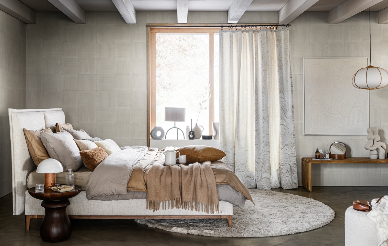 Behang Sweep 53042/53041 uit collectie Essentials Modulaire (arte-international.com). Gestoffeerd bed met hoofdbord en massief houten poten (borstbedden.nl). Houten bijzettafel (roche-bobois.com). Karaf met glas (letoile.store). Houten tafellamp, beige leren dienblad, wollen plaid, wit kussen met bruine bies, metalen tafellamp met grijs fluwelen kap, witte vaas, beige vaas met handvat (zarahome.com). Dekbedovertrekken in grijs en lichtbruin, per stuk vanaf, dienblad, houten opberger met deksel, grijze vaas organische vorm, marmeren dienblad, hanglamp van bamboe en papier (hm.com). Bruin kussen (paviljoennoord.com). Wit wollen kussen Mousson , grijs wollen kussen Cormo Zinc -, gordijn Aurelia Chalk van Designers Guild, per meter (wva.nl). Leren kussen (bolia.com). Rond vloerkleed Frankly, prijs op aanvraag (kasstoor.nl). Vaas met opening , houten bank, 96x43x38 cm (lxhxd) (hkliving.nl). Sculptuur (2222studio.com). Kunstwerk uit The Heritage Series prijs op aanvraag (heritageseries.com). Bouclé poef No. 9 (sofacompany.com). Overig privébezit.
