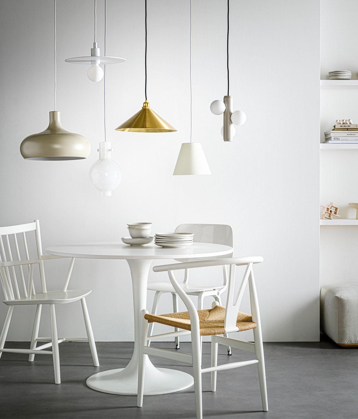 Hanglampen v.l.n.r.: beige hanglamp Växjö, 26×38 cm (hxØ) € 29,95 (ikea.com). Witte, stalen hanglamp Nod M, 30 cm (Ø) € 299,- (studio-henk.nl). Hanglamp Novecento in borosilicaatglas, 32×20 cm (hxØ) € 163,- (serax.com). Messing hanglamp Cone Shade M, 12,2×36 cm (hxØ) € 450,- (framacph.com). Witte kunststof hanglamp Sinker small van Hay, , 19×23 cm (hxØ) € 186,- (vtwonen.nl). Beige hanglamp Kaktee met 3 lichtbronnen, mat gepoedercoat metaal en opaalglas, 24×21 cm (hxØ) € 249,- (festamsterdam.com). Eettafel Docksta, 75×103 cm (hxØ) (ikea.com). Kunststof stoel Revolt van Ahrend € 359,- (misterdesign.nl). Houten stoel CH_24 Wishbone Chair van Hans J. Wegner met gevlochten zitting , € 556,- (kasstoor.nl). Witte spijlenstoel J42 van Hay € 315,- (vtwonen.nl). Gebaksborden per stuk € 8,25, schaal € 12,50, ontbijtborden per stuk € 12,50, kommen per stuk € 10,95 (loods5.nl). Porseleinen kunstobjecten Sculpture Maida €90,-, Sculpture Azi structured € 150,-, keramieken schaal op voet Moon Totem € 190,- (studio-yen.com). Poef Otto L met Royal Pearl stoffering en eiken basis, vanaf € 550,- (studio-henk.nl). Overig privébezit.