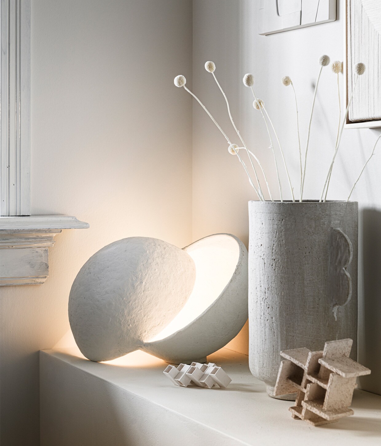 Bolvormige papier-maché lamp van ontwerper Marie Michielssen. Doordat de twee vormen over elkaar vallen, blijft de lichtbron onzichtbaar € 245,- (serax.com). Aardewerken vaas van Urban Nature Culture € 49,99 (sissy-boy.com). Porseleinen kunstwerken Sculpture Maida € 90,-, Sculpture Azi Structured € 150 (studio-yen.com)., ,