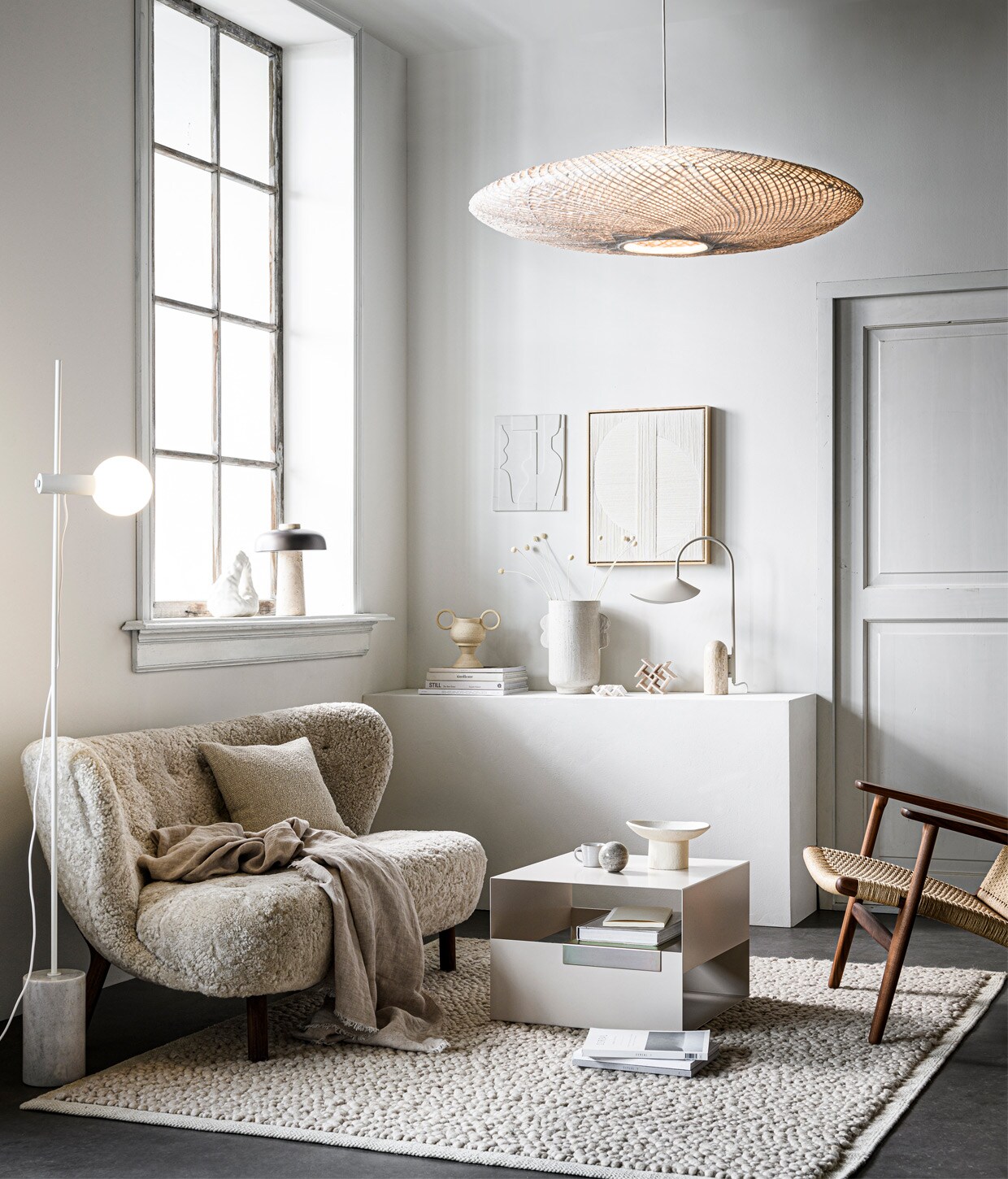 Bank Little Petra van &amp;Tradition, walnoothouten poten en sheepskin Moonlight bekleding, 150x80x75 cm (bxdxh) € 6183,- (andtradition.com). Fauteuil CH25 van Hans J. Wegner, van geolied walnoot met zitting en leuning van geweven papierkoord, € 3629,- (kasstoor.nl). Vloerkleed Gravel Ivory van Menu, 170×200 cm € 810,- (thefinestore.com). Vloerlamp Revolve met marmeren voet, 158,5 cm hoog, bol van opaalglas 13,5 cm (Ø) € 459,-, kussen 40×40 cm € 136,- (bolia.com). Metalen salontafel Axe, 50x50x35 cm (bxdxh) € 329,- (festamsterdam.com). Tafellamp Reverse van Menu € 550,- (designtales.nl). In het raamkozijn: witte porseleinen boekensteun Boulder van Hay € 75,- (vtwonen.nl). Porseleinen kunstobjecten Sculpture Maida € 90,-, Sculpture Azi Structured € 150,-, vaas in twee delen met twee oren uit serie Earth Vases, per onderdeel van € 30,- tot € 57,50, keramieken schaal op voet Moon Totem € 190,-, kunstwerk Mirrors met eikenhouten lijst € 500,-(studio-yen.com). Linnen plaid, 140×190 cm € 79,99 (zarahome.com). Aardewerken vaas met oren van Urban Nature Culture € 49,99 (sissy-boy.com). Tafellamp Arum van Ferm Living, marmeren voet en gepoedercoat staal, 20,5x50x34 cm (bxhxd) € 405,- (fermliving.com). Bamboe hanglamp Ufo, 21×82 cm (hxØ) € 495,-, wit aardewerken kunstwerk 26,6×23,5 cm € 49,95 (hkliving.nl). Espressomok met oor , € 4,25 (loods5.nl). Overig privébezit.