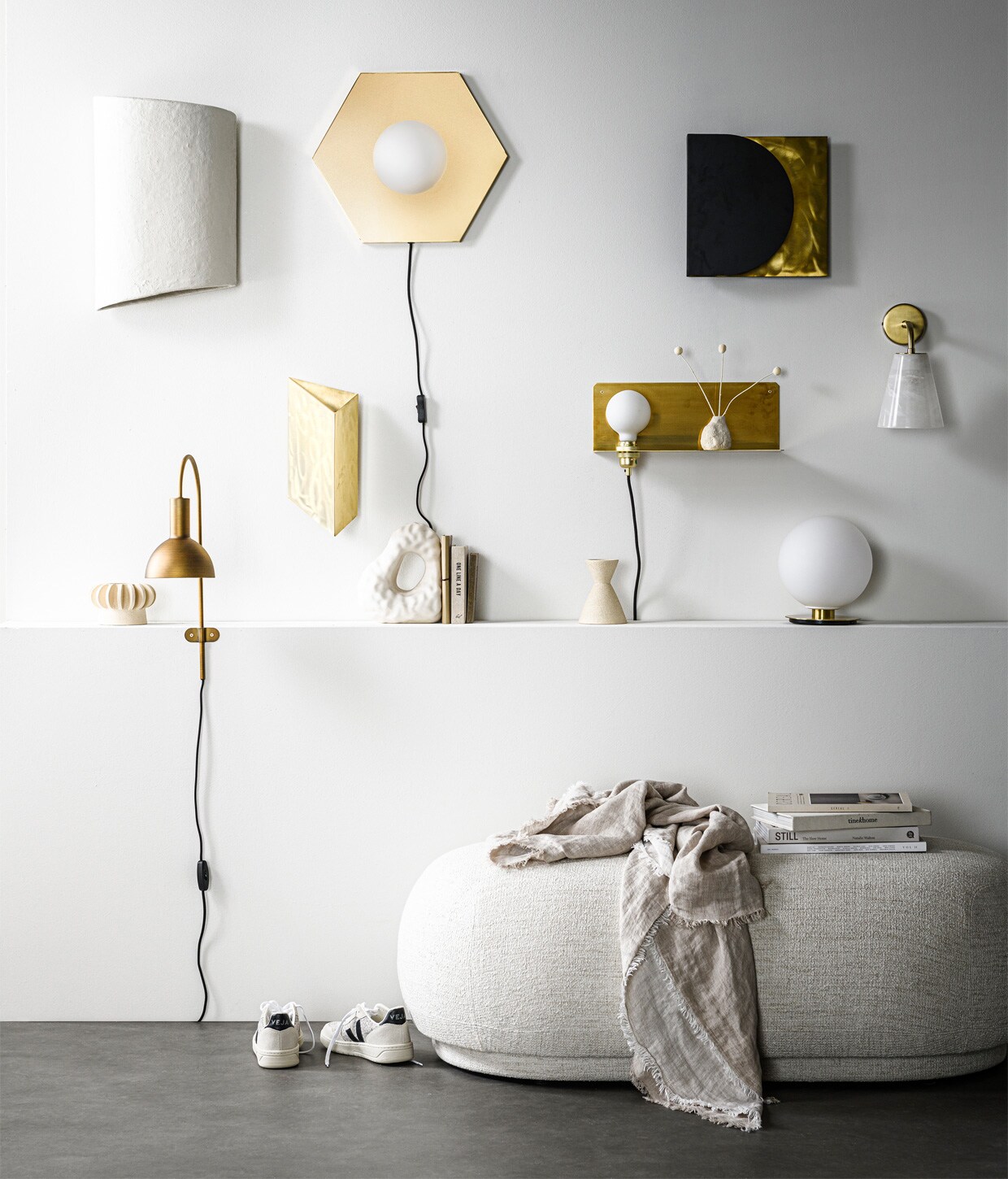 wandlamp White Earth van papier-maché, 45x31x16 cm (hxlxb) € 209,- (serax.com). Zeshoekige wand- of plafondlamp Holo, messing coating en opaalglas, 42×36,5×8,5 cm (bxhxd) € 299,- (festamsterdam.com). Wandlamp in zwart en messing € 249,-, driehoekige messing wandlamp van ontwerper Koen van Guijze € 390,- (serax.com). Messing wandplank met verlichting van Frama, 15x40x15 cm € 325,- (wonenmetlef.nl). Wandlamp met albasten kap en goudkleurige metalen voet, 18,5×26,5×14 cm € 169,- (zarahome.com). Messing wandlamp Oscar, 36x14x25 cm (lxbxh) € 49,95 (karwei.nl). Bollamp van opaalglas op geborstelde messing voet uit TR collection van Menu € 259,40 (vtwonen.nl). Kleine wit geglazuurde stenen vaas Vulca van Ferm Living € 15,- (wonenmetlef.nl). Ovale poef Rico Ottoman van , Ferm Living, 41x124x69 cm (hxbxd) € 1219,-, porseleinen boekensteun Boulder van Hay € 75,- (vtwonen.nl). Linnen plaid,140×190 cm € 79,99 (zarahome.com). Gympen van Veja € 125,- (bellerose.be). Vazen met losse onderdelen, om te stapelen of los van elkaar neer te zetten, per onderdeel van € 30,- tot € 57,50 (studio-yen.com). Overig privébezit.